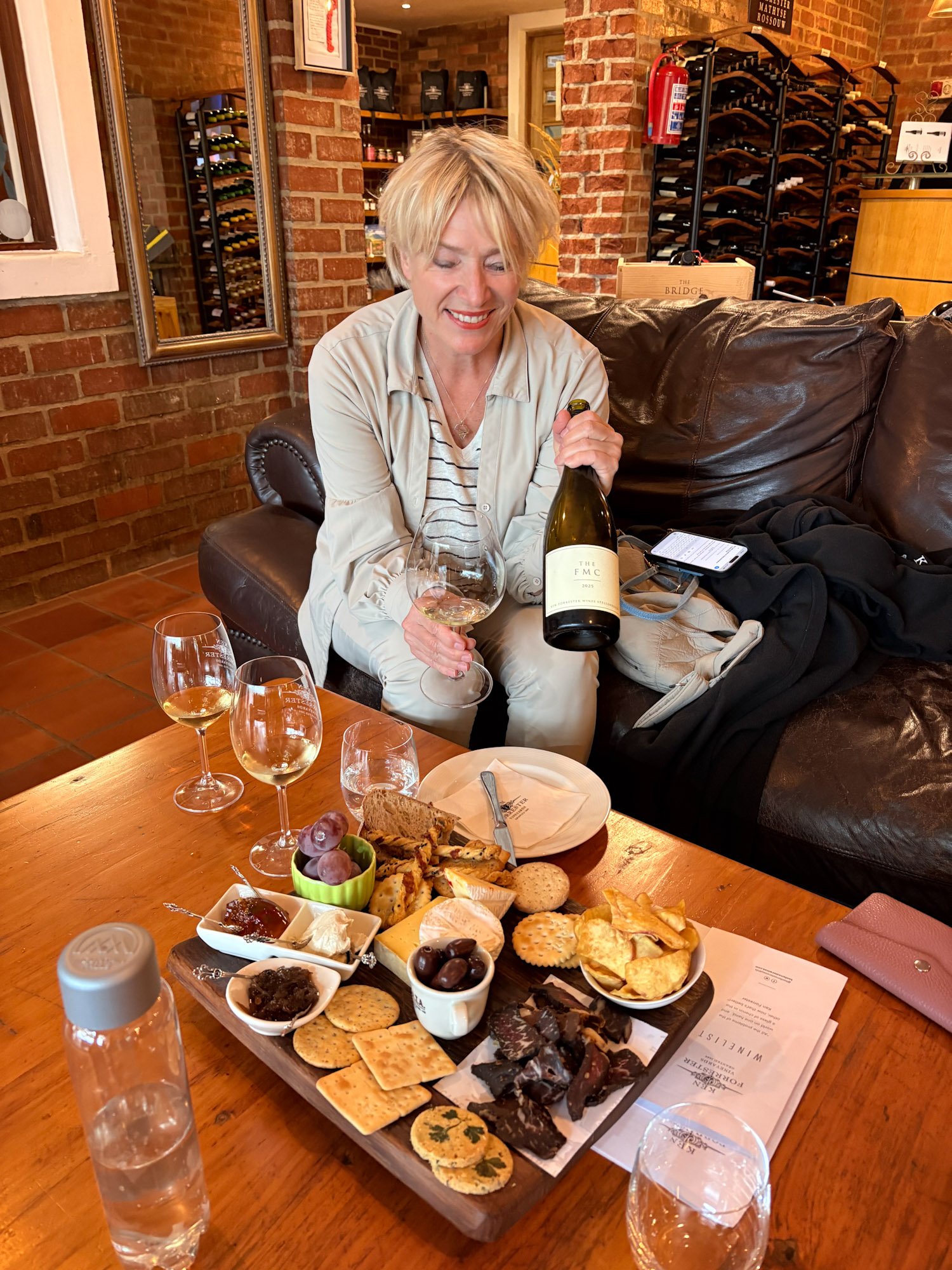 Vrouw met wijnplank en glas wijn tijdens proeverij bij Ken Forrester Wines in Stellenbosch.