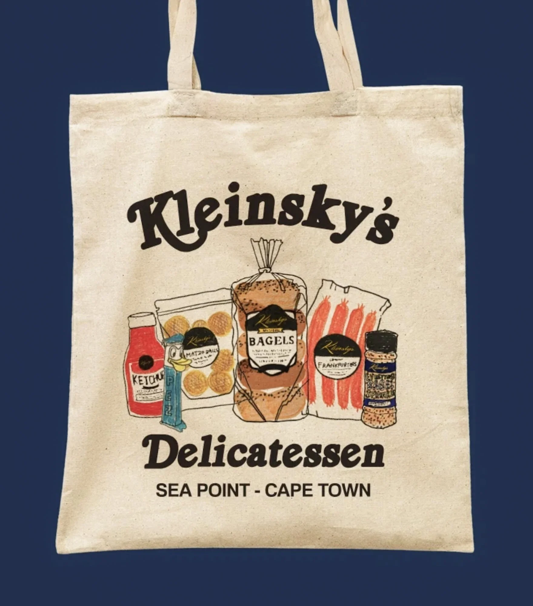 Linnen tas van Kleinsky's Delicatessen met illustraties van bagels en delicatessen uit Sea Point in Kaapstad.