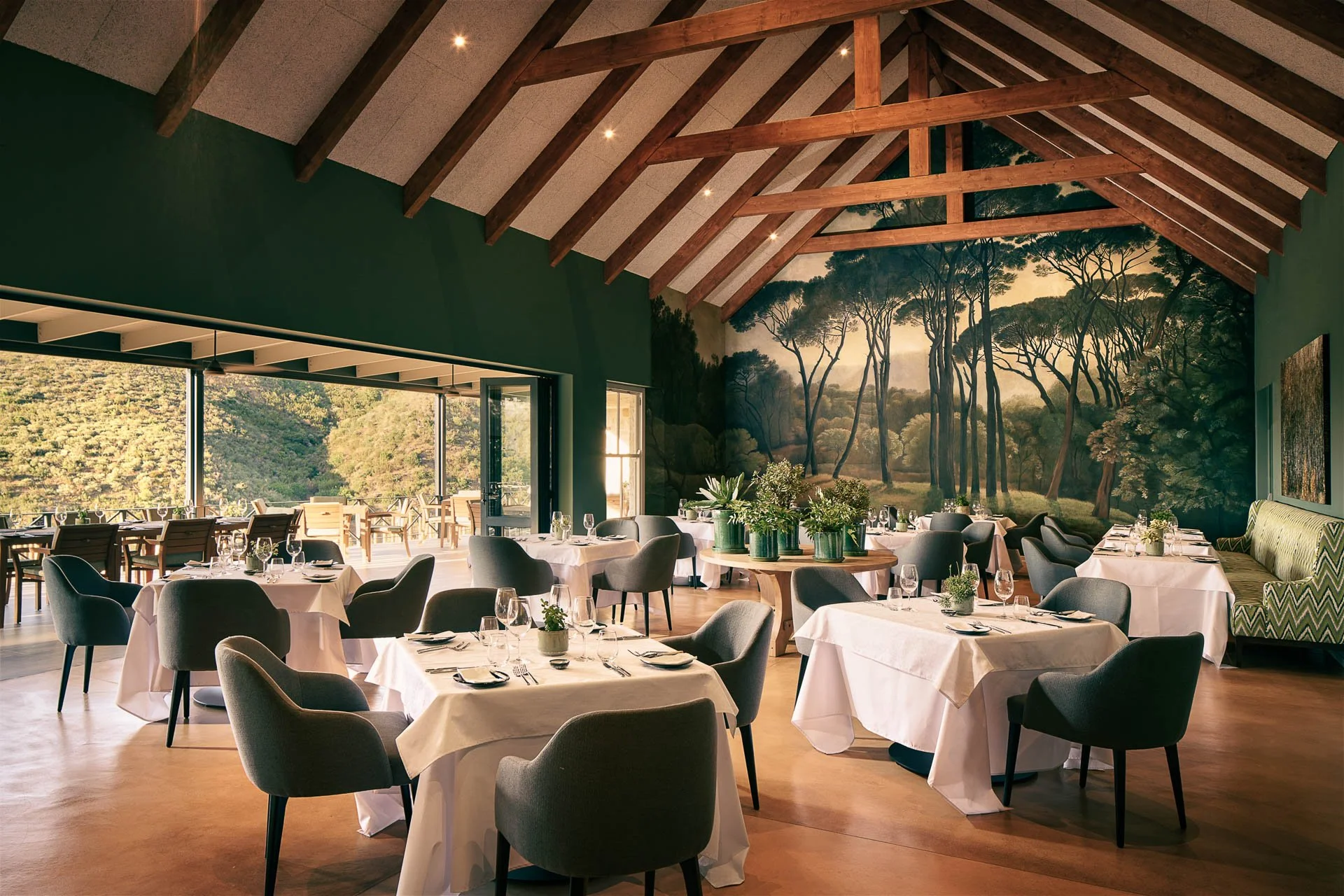 Restaurantinterieur Bistro met gedekte tafels en uitzicht op terras en groen landschap