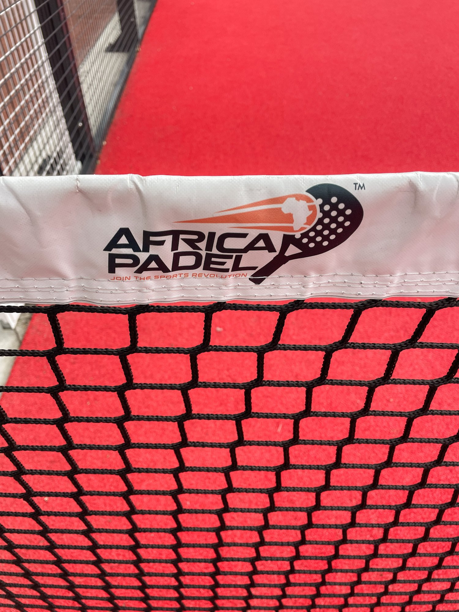 Padelnet met Africa Padel logo op een rode baan in Zuid-Afrika.