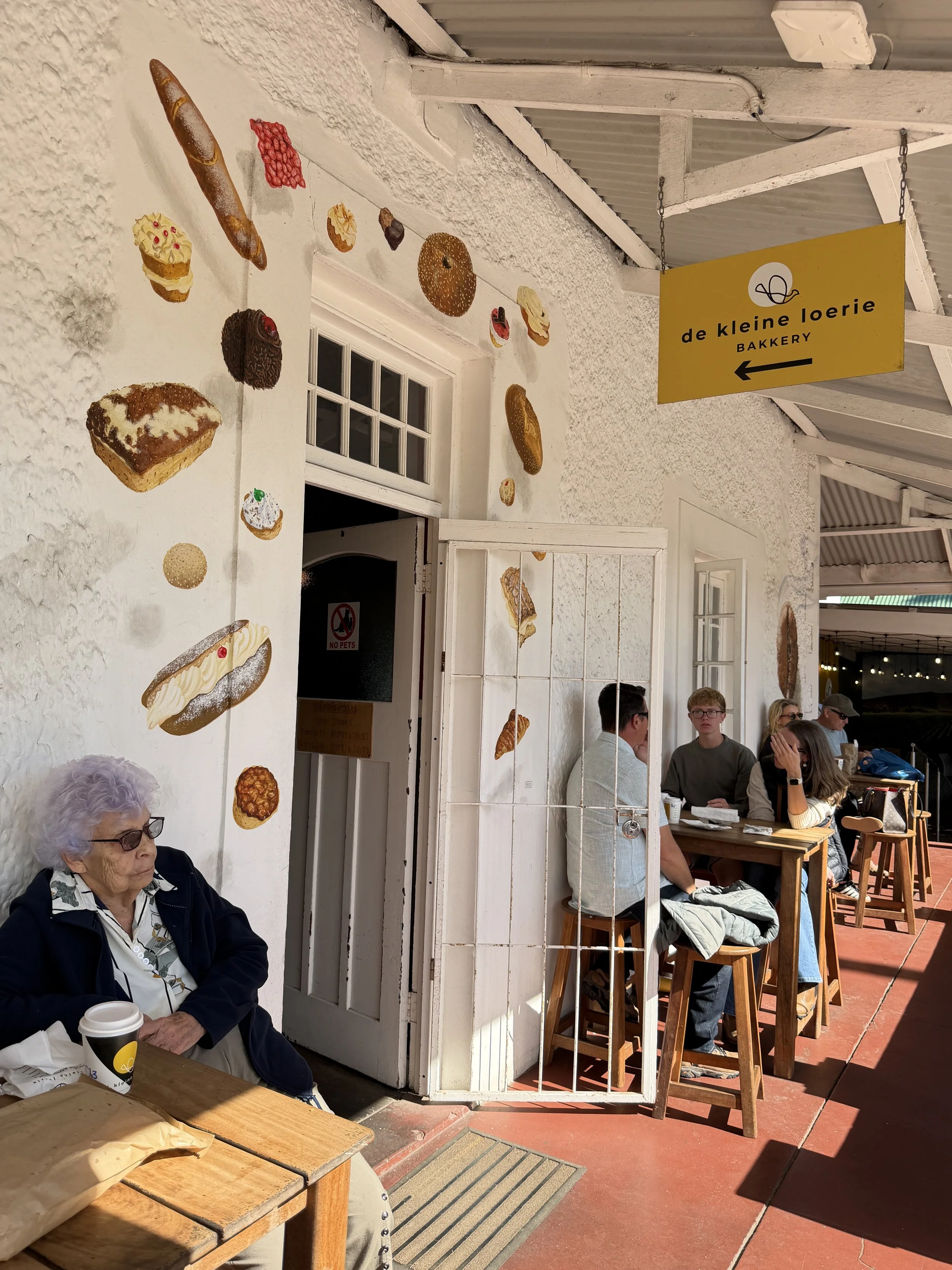 Terras van De Kleine Loerie Bakery met bezoekers in Zuid-Afrika