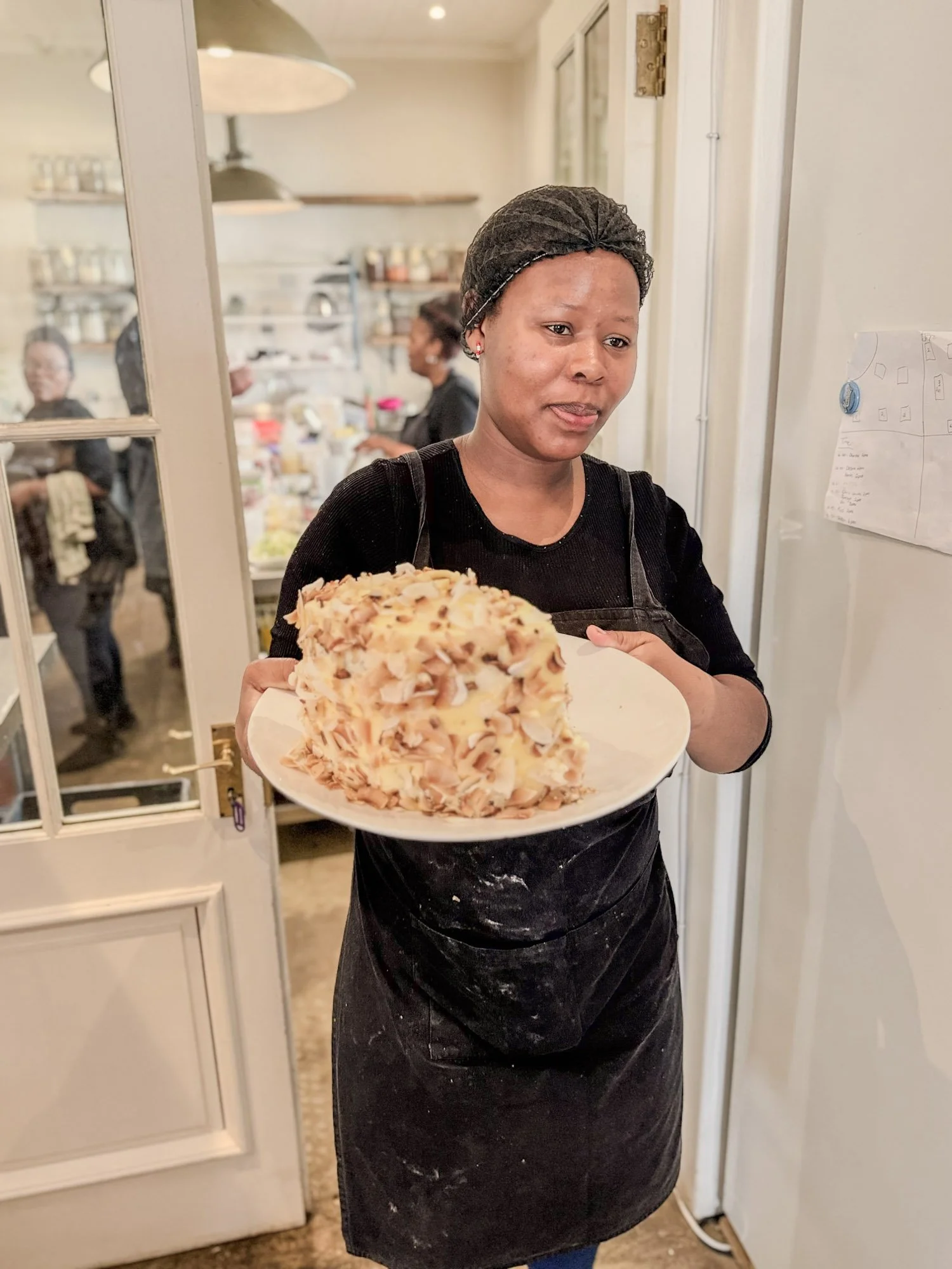 Medewerkster presenteert een versgebakken kokoscake in een bakkerij in Stanford.