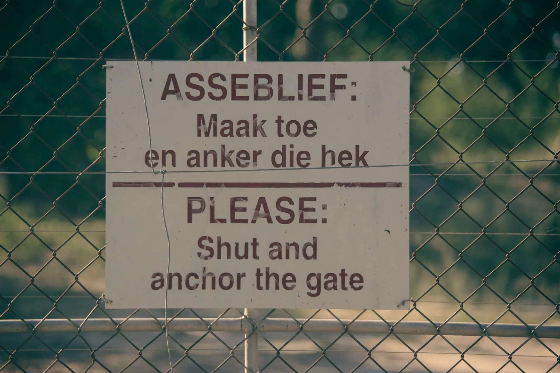 Bord met Afrikaanse en Engelse tekst vraagt om het hek te sluiten in Zuid-Afrika.