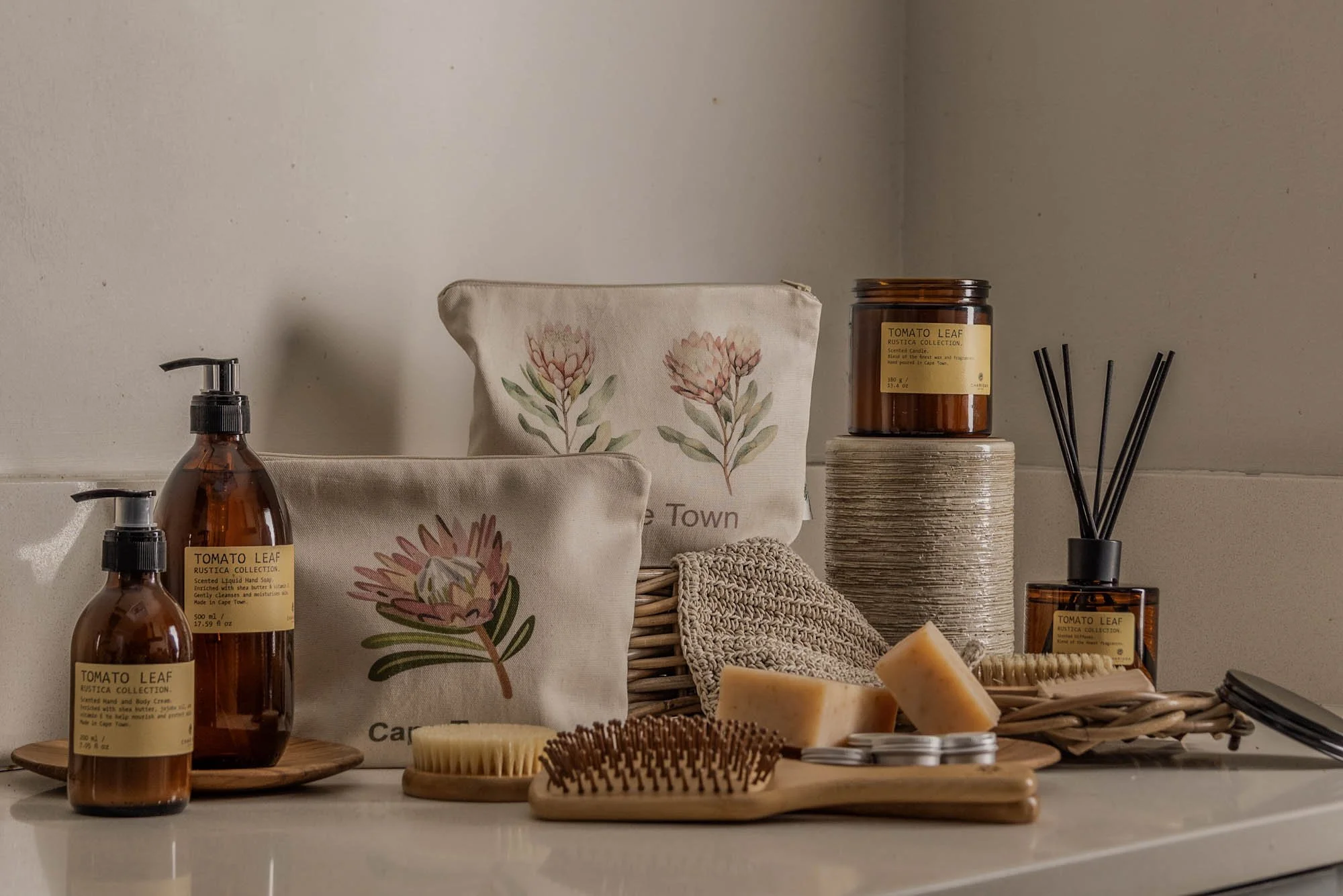 Verzorgingsproducten, borstels en etuis met proteamotief van Cape Home Collective.