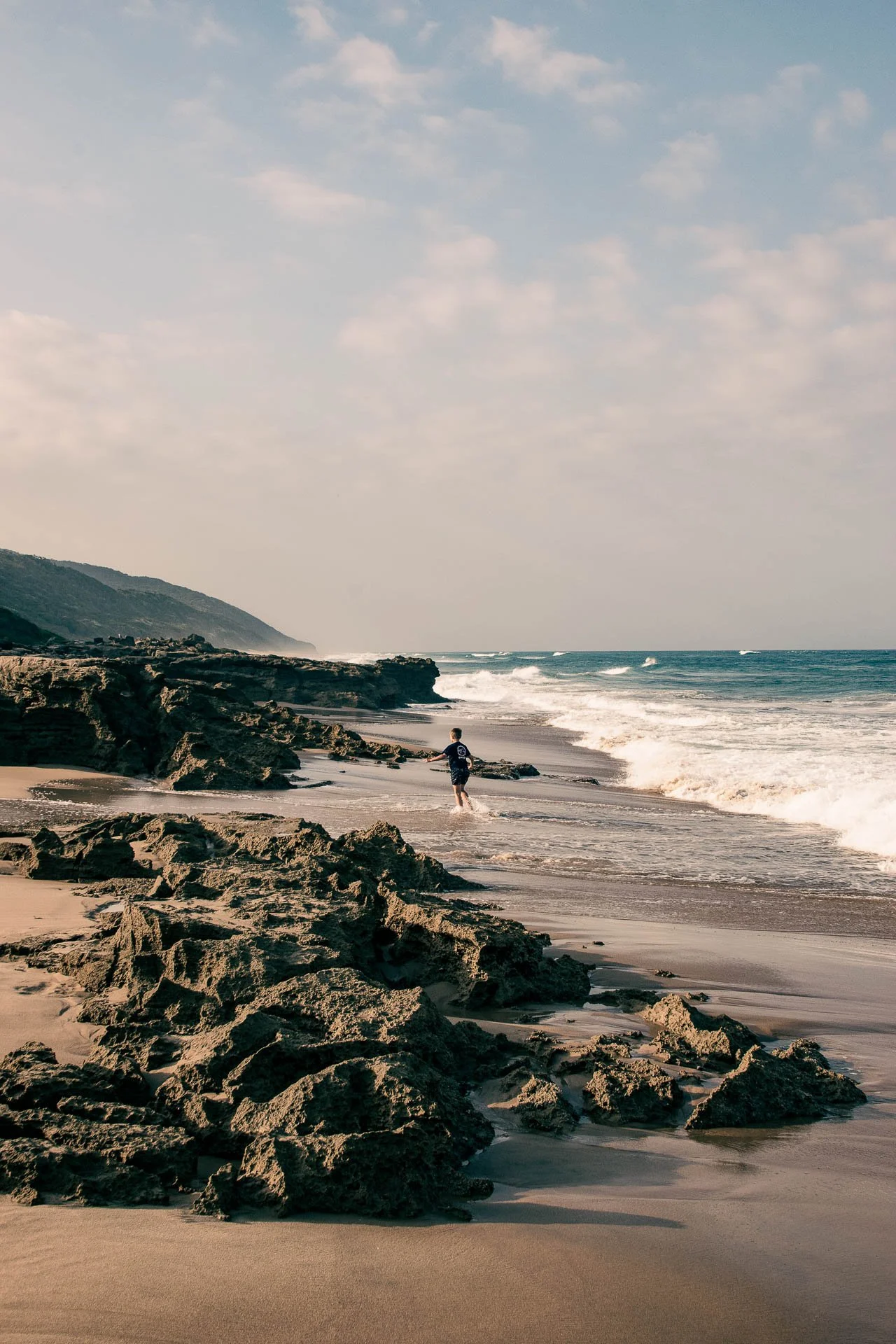 Rotsachtig strand met golven langs de kust bij St Lucia in Zuid-Afrika.