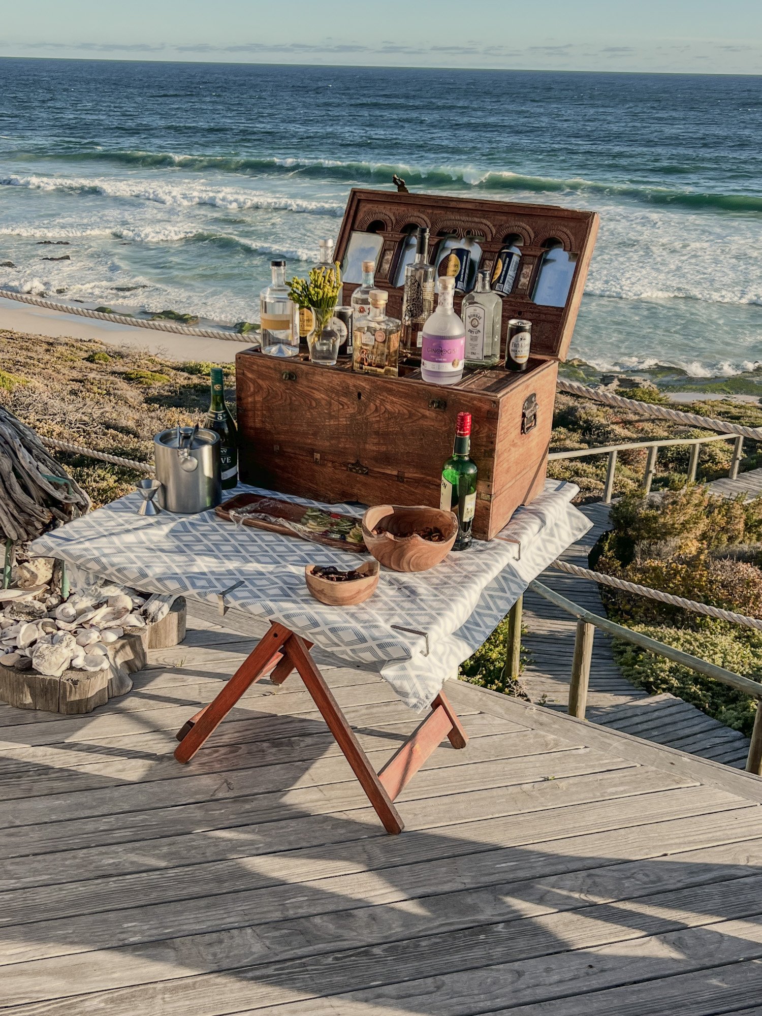 Tafel met verschillende soorten gin met de zee op de achtergrond in Zuid-Afrika.
