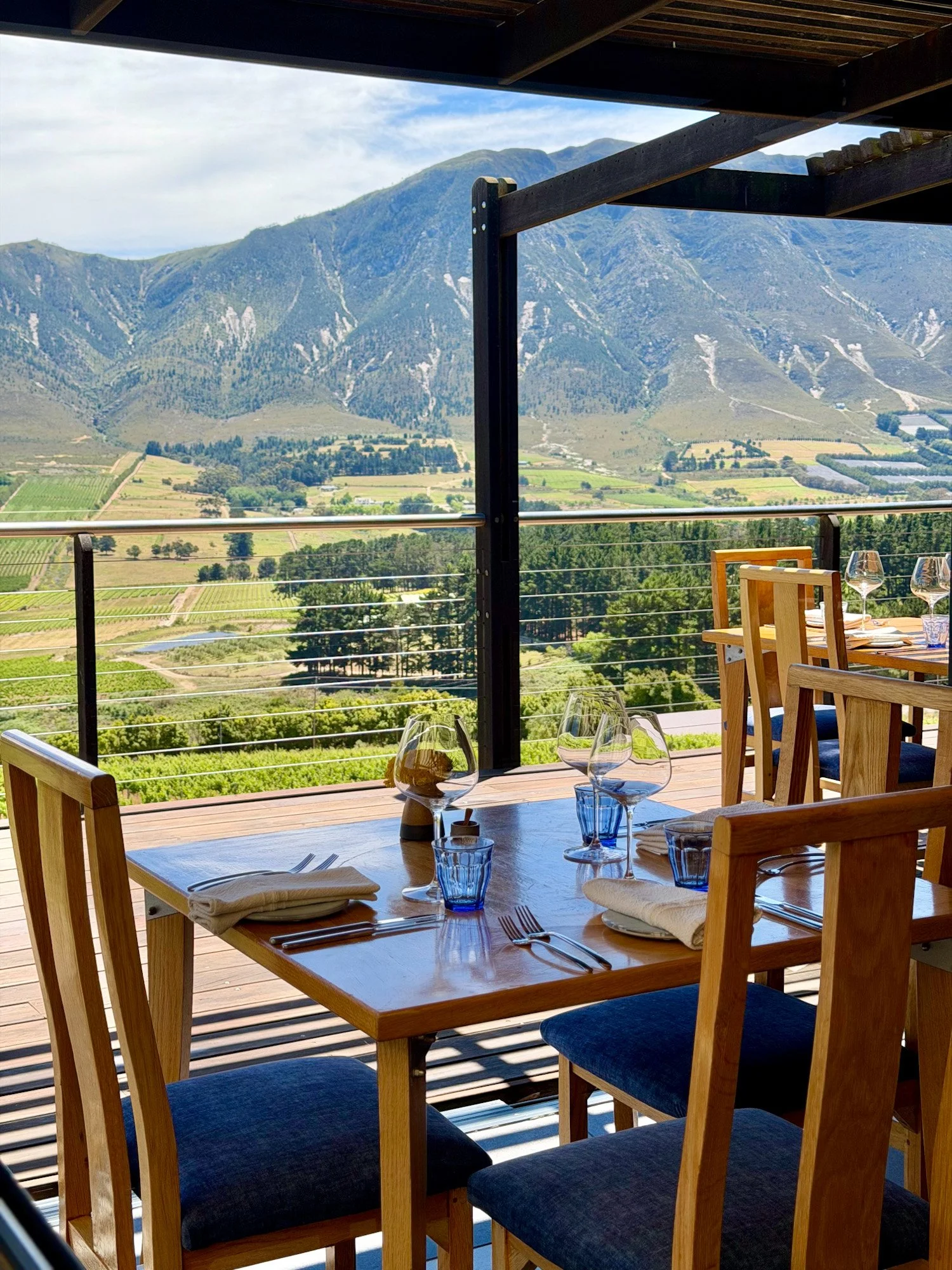 Gedekte tafel bij Newton Johnson restaurant en uitzicht over de Hemel-en-Aarde vallei in Zuid-Afrika.