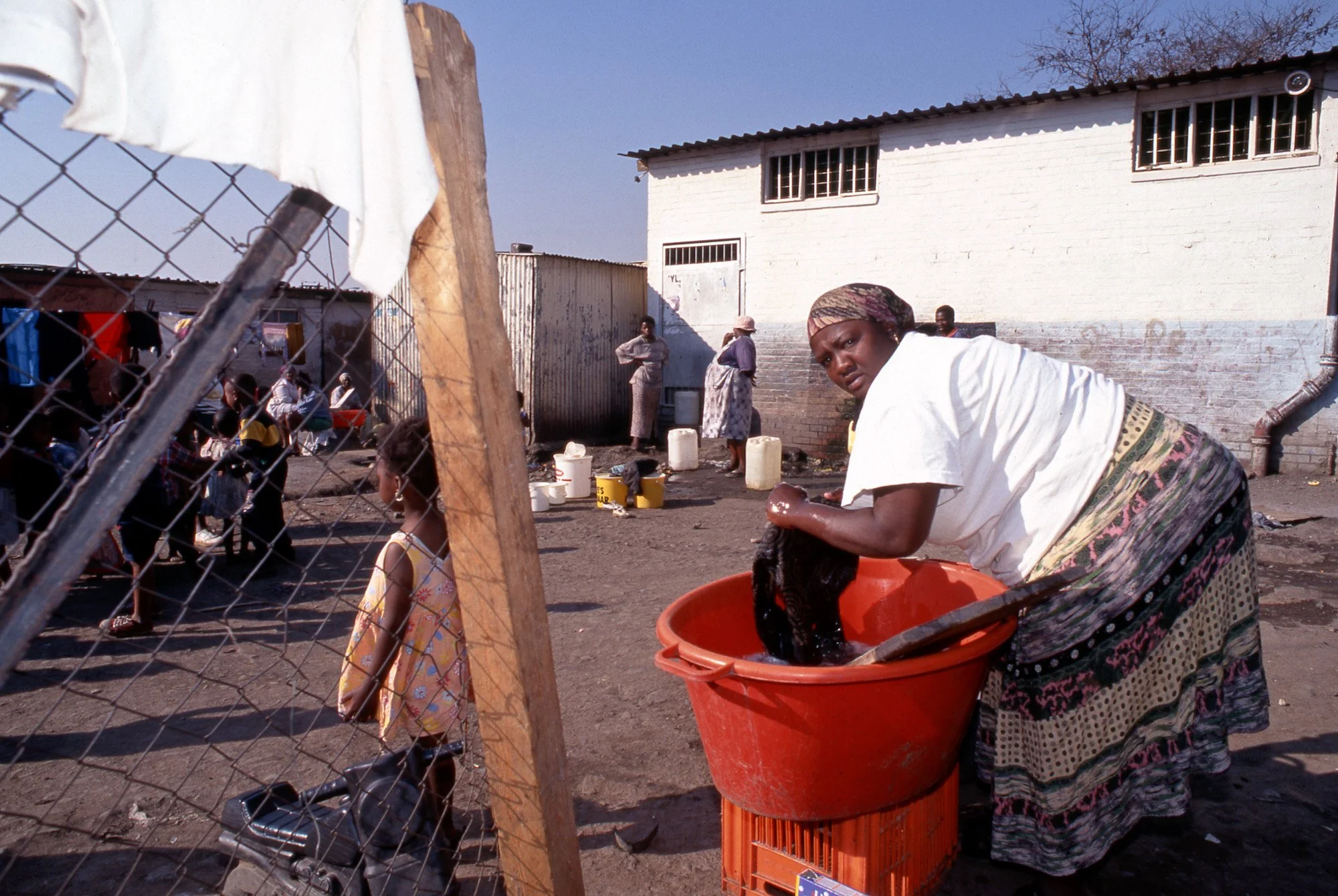 Soweto, Zuid-Afrika, vrouw doet was in rode teil.
