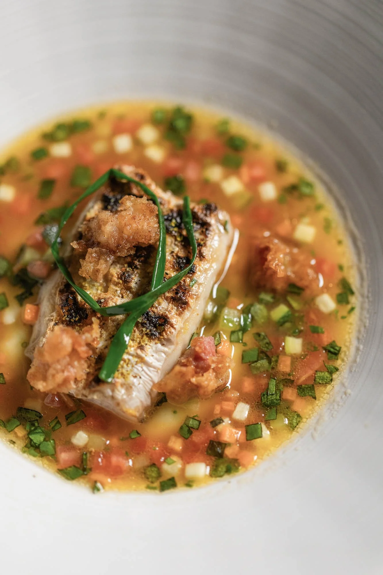 Visgerecht met fijngesneden groenten en kruiden in een lichte bouillon bij Mertia in Stellenbosch.