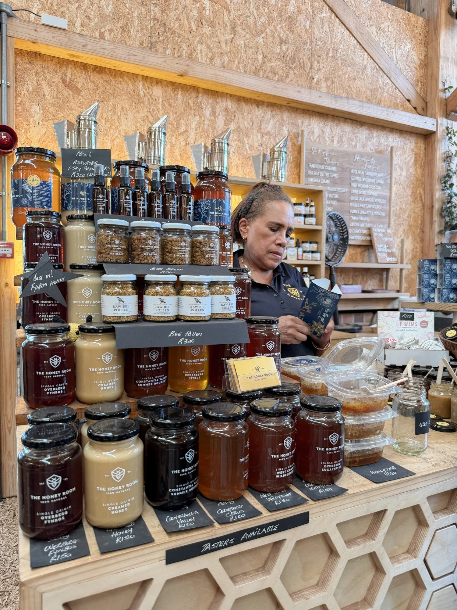 Kraam met potten honing en bijenproducten van The Honey Room op een markt in Zuid-Afrika.