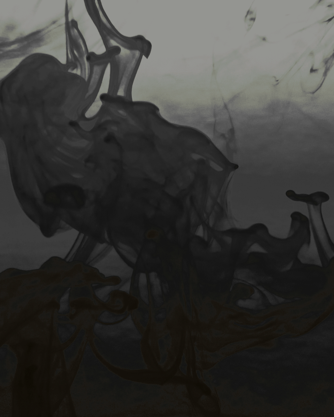 Abstract black ink swirling in water with shades of gray.