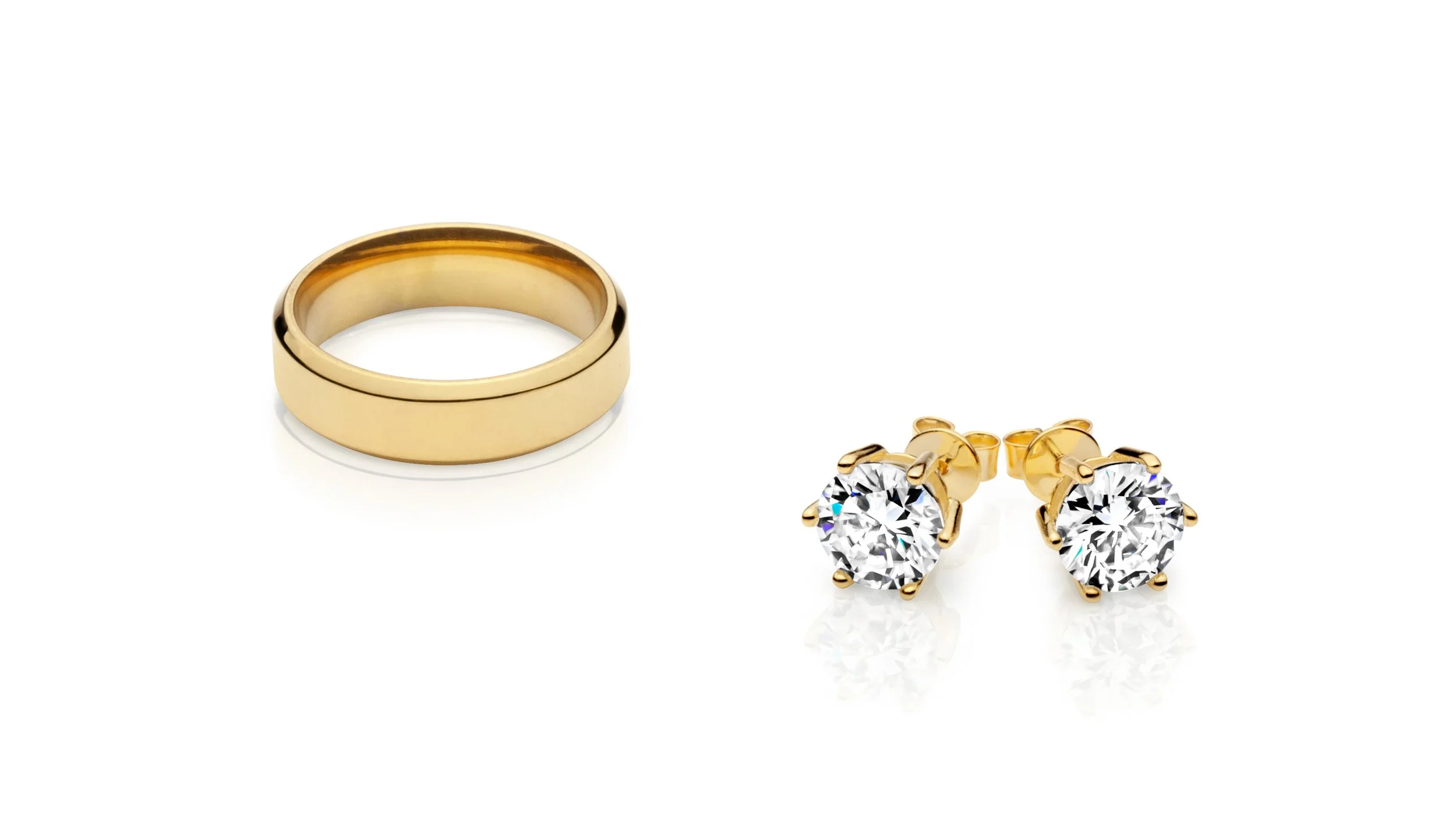 Professional jewelry picture of Gold ring and pair of gold stud earrings with large clear gemstones on a white background.