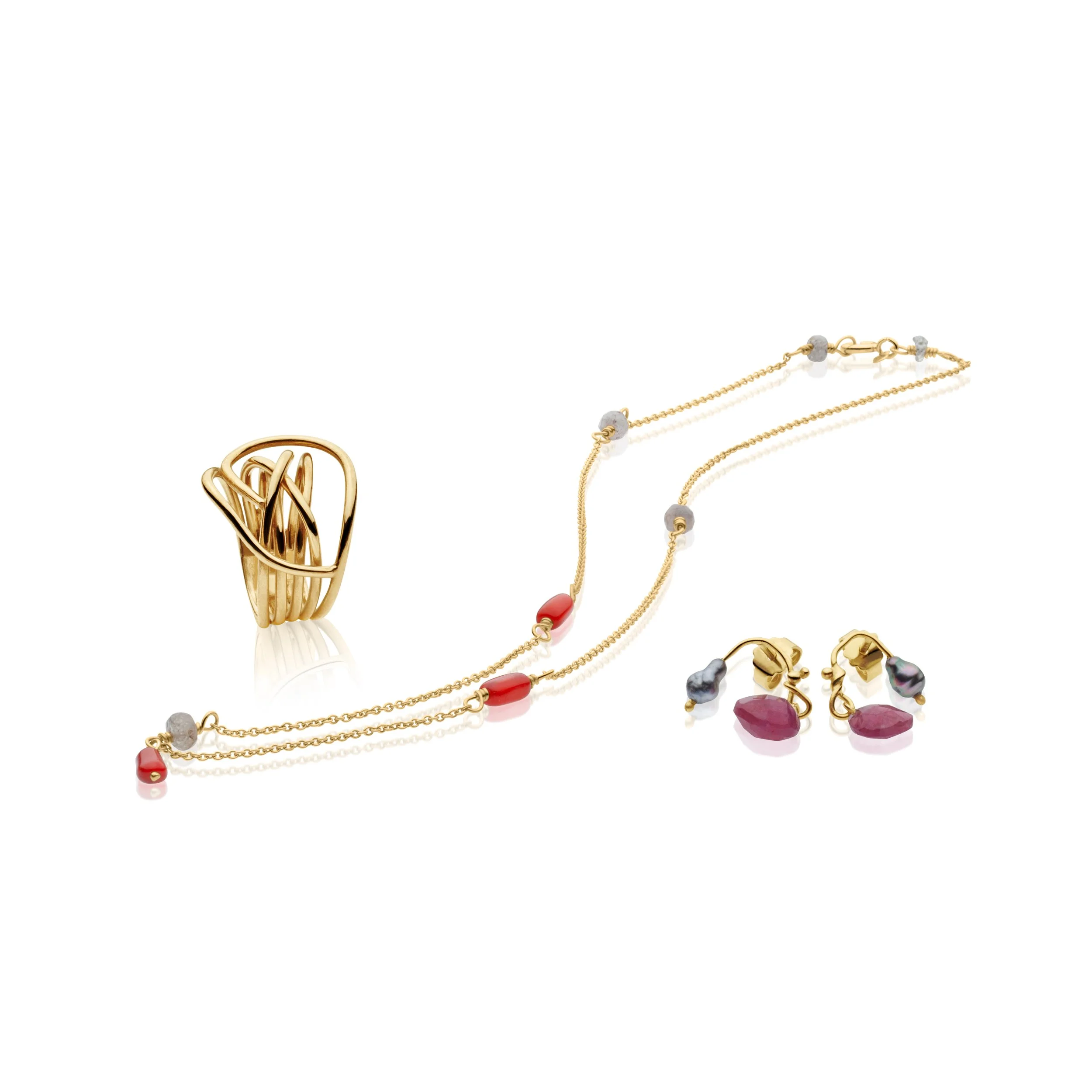 Professional jewelry picture of Gold jewelry set including a ring, a necklace, and earrings with red and purple stones, arranged on a white background.