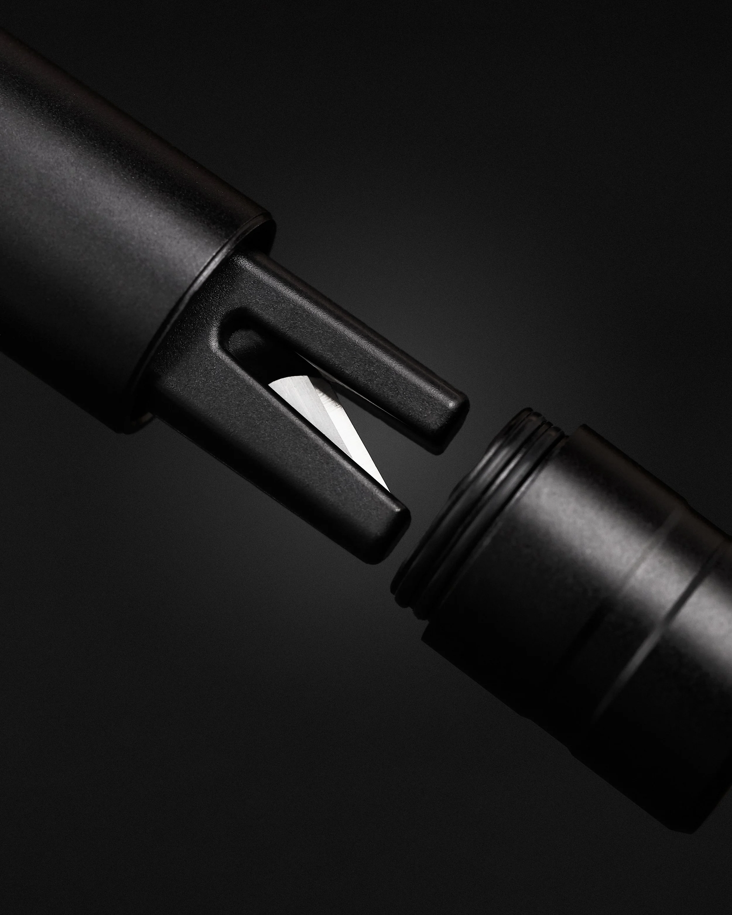 Tampa de uma canivete suíço preto com lâmina parcialmente aberta em fundo preto.
Black Swiss Army knife lid with partially open blade on black background.