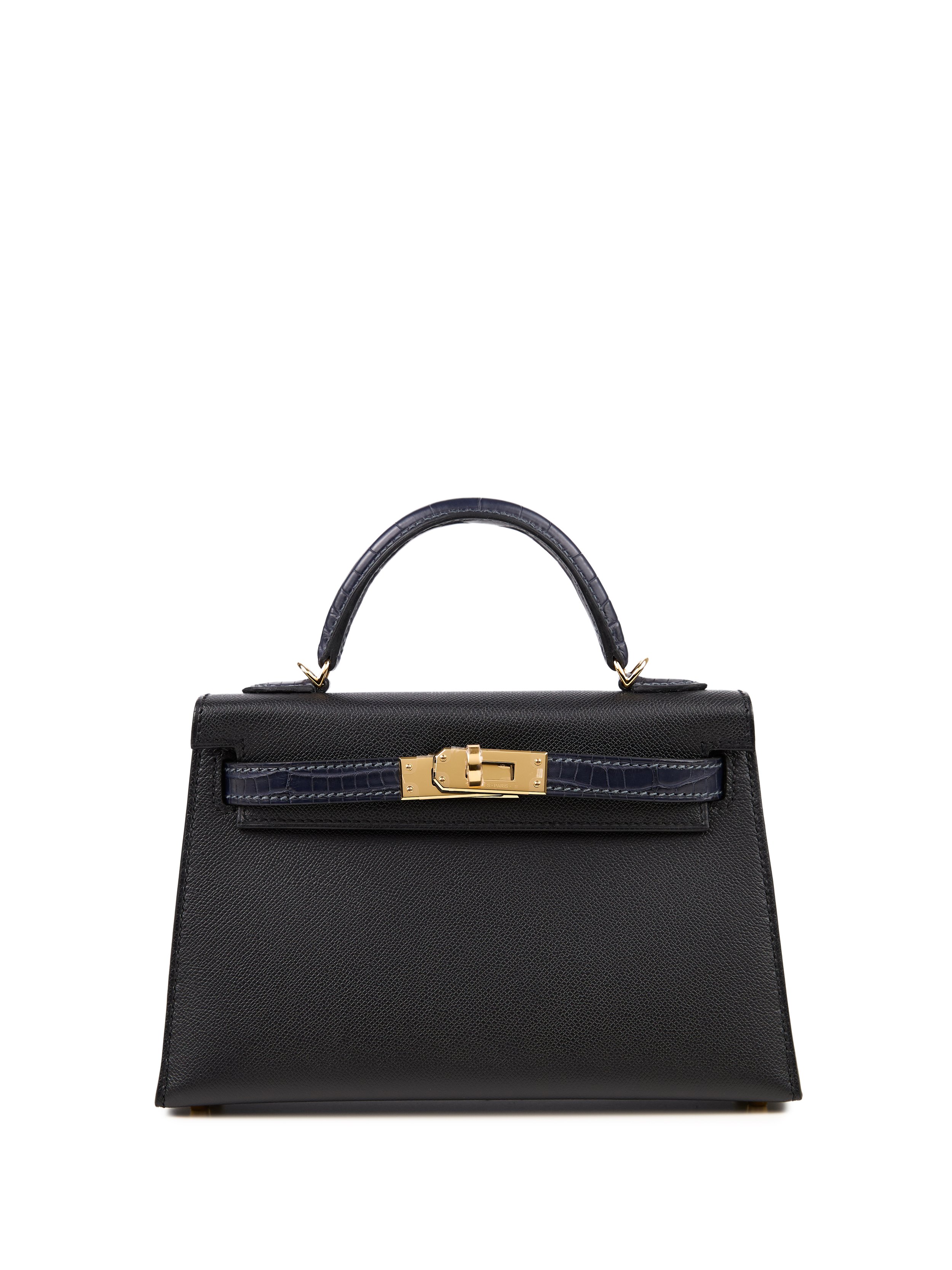 A black designer handbag with gold hardware and a textured surface, featuring a top handle and a structured shape.