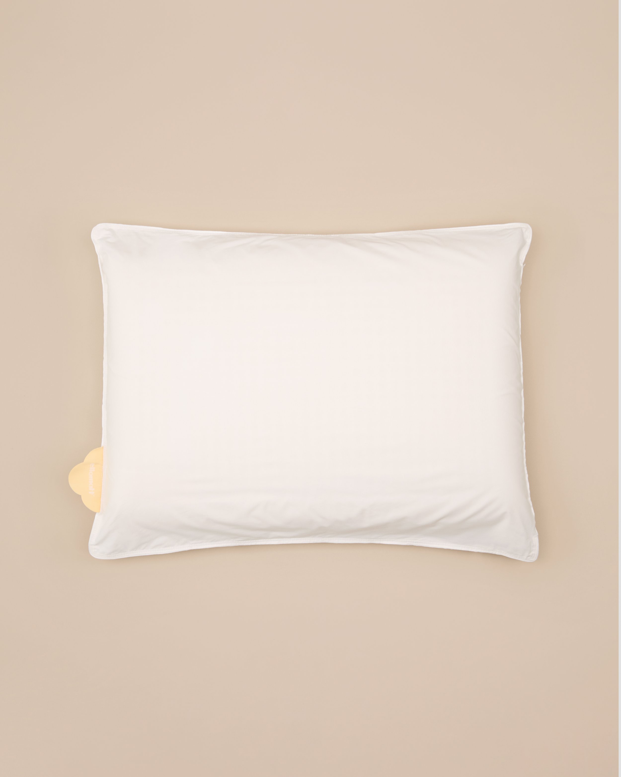 White pillow on beige background.