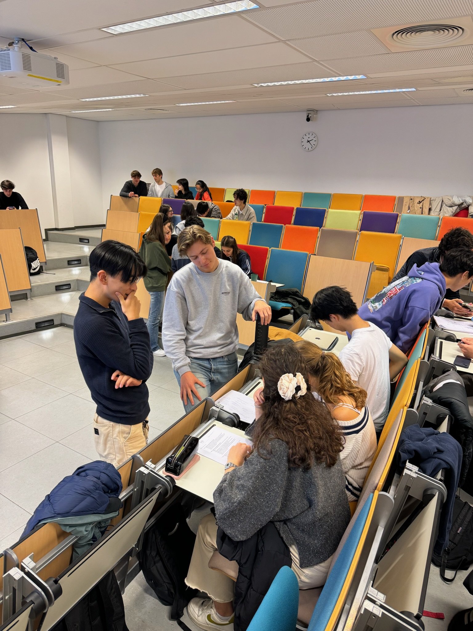 Students working together in groups during a workshop in a colorful lecture hall at Erasmus University.