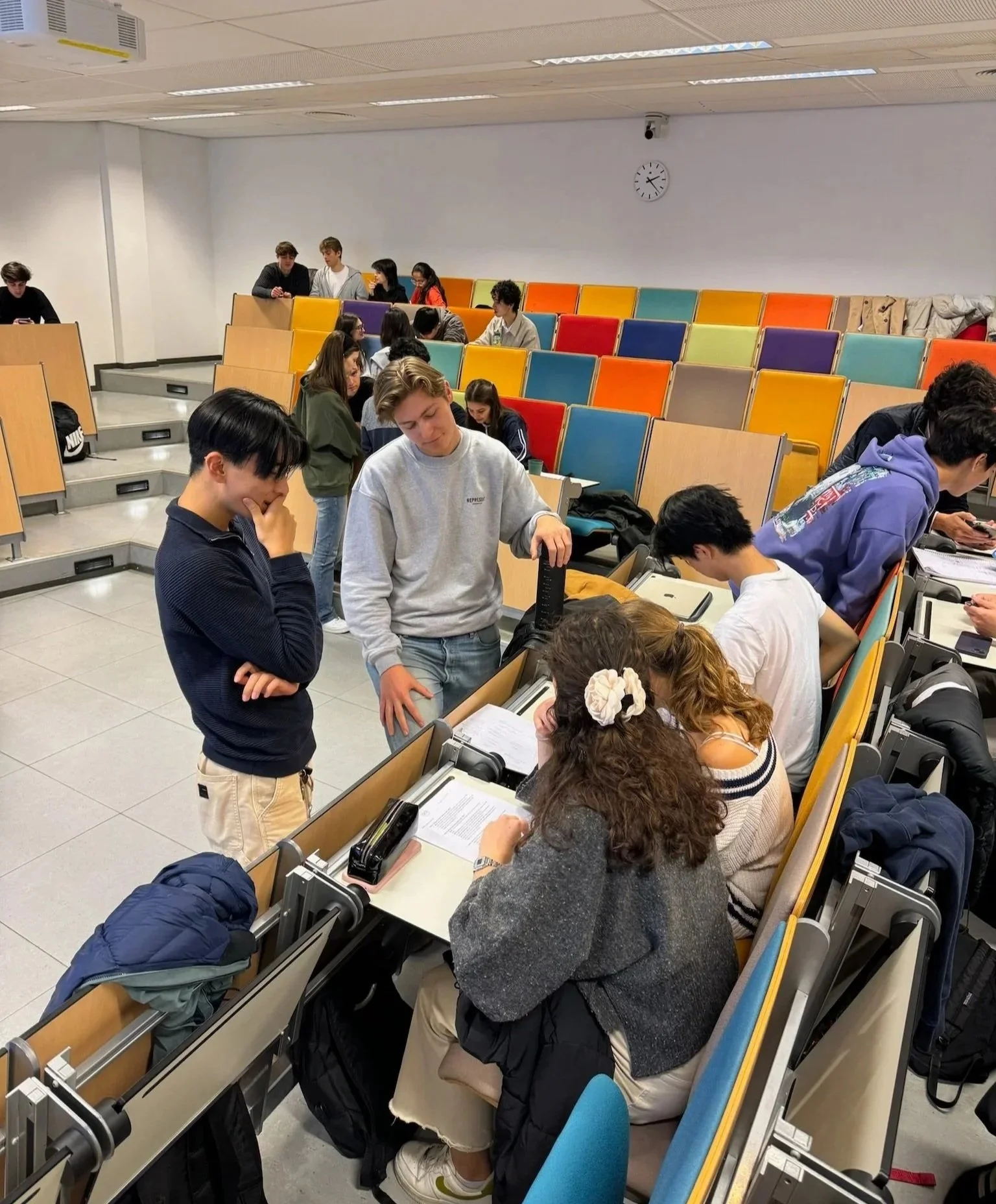 Students working together in groups during a workshop in a colorful lecture hall at Erasmus University.