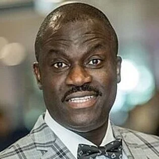 Portrait of a man wearing a patterned suit and bow tie.