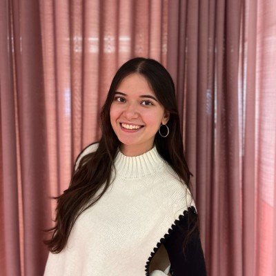 Portrait of a young woman with long dark hair in a white sweater.
