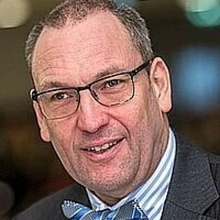 Portrait of an older man in a suit and bow tie.