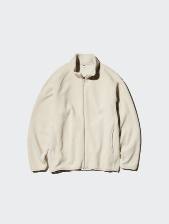 Cream-colored zip-up fleece jacket with a stand-up collar and side pockets, laid flat on a light background.