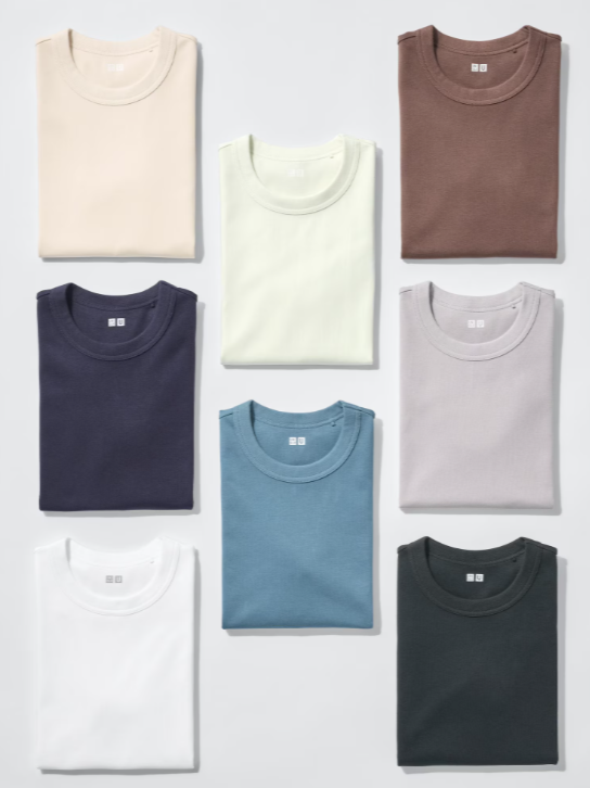 Nine folded T-shirts in different colors arranged in a grid on a white surface.