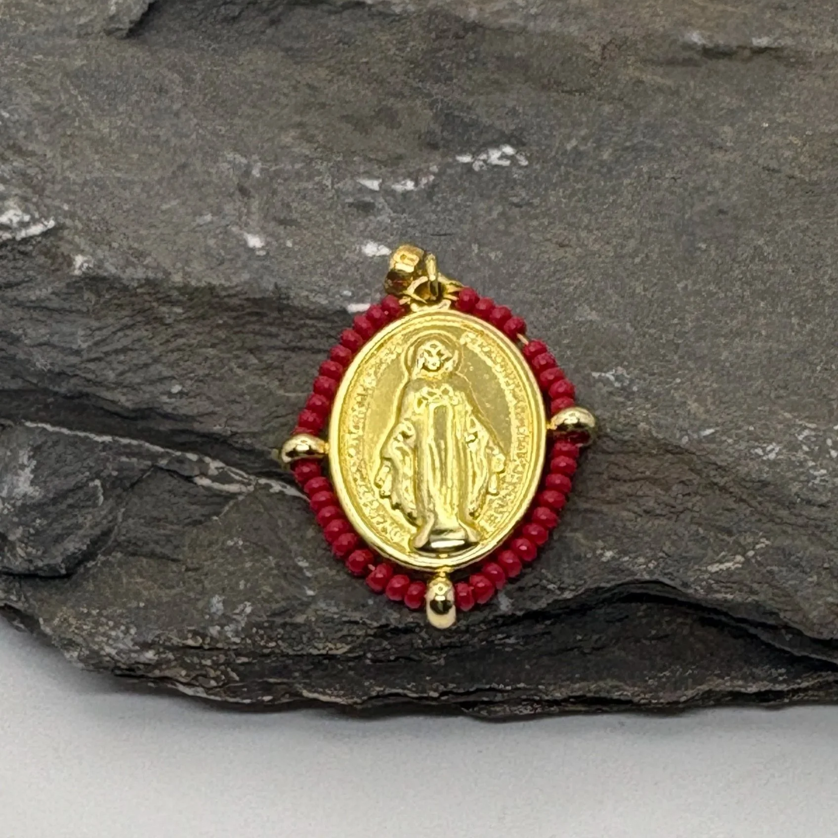 Oval 18K gold plated Virgin Mary charm with a dark red bead surround