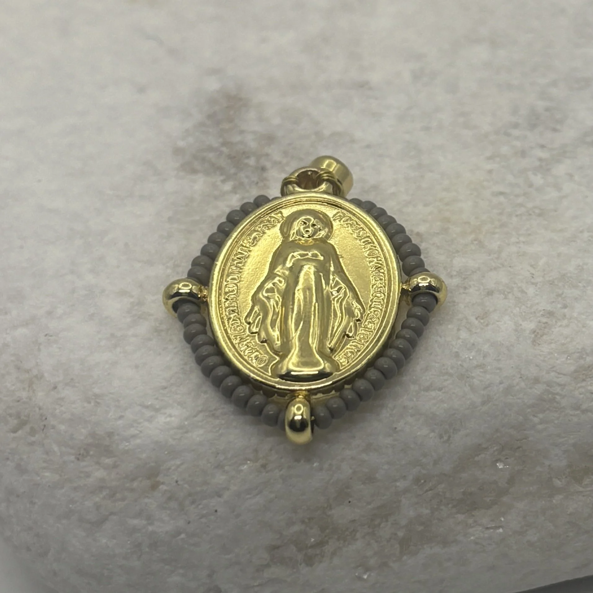 Oval 18K gold plated Virgin Mary charm with a grey glass bead