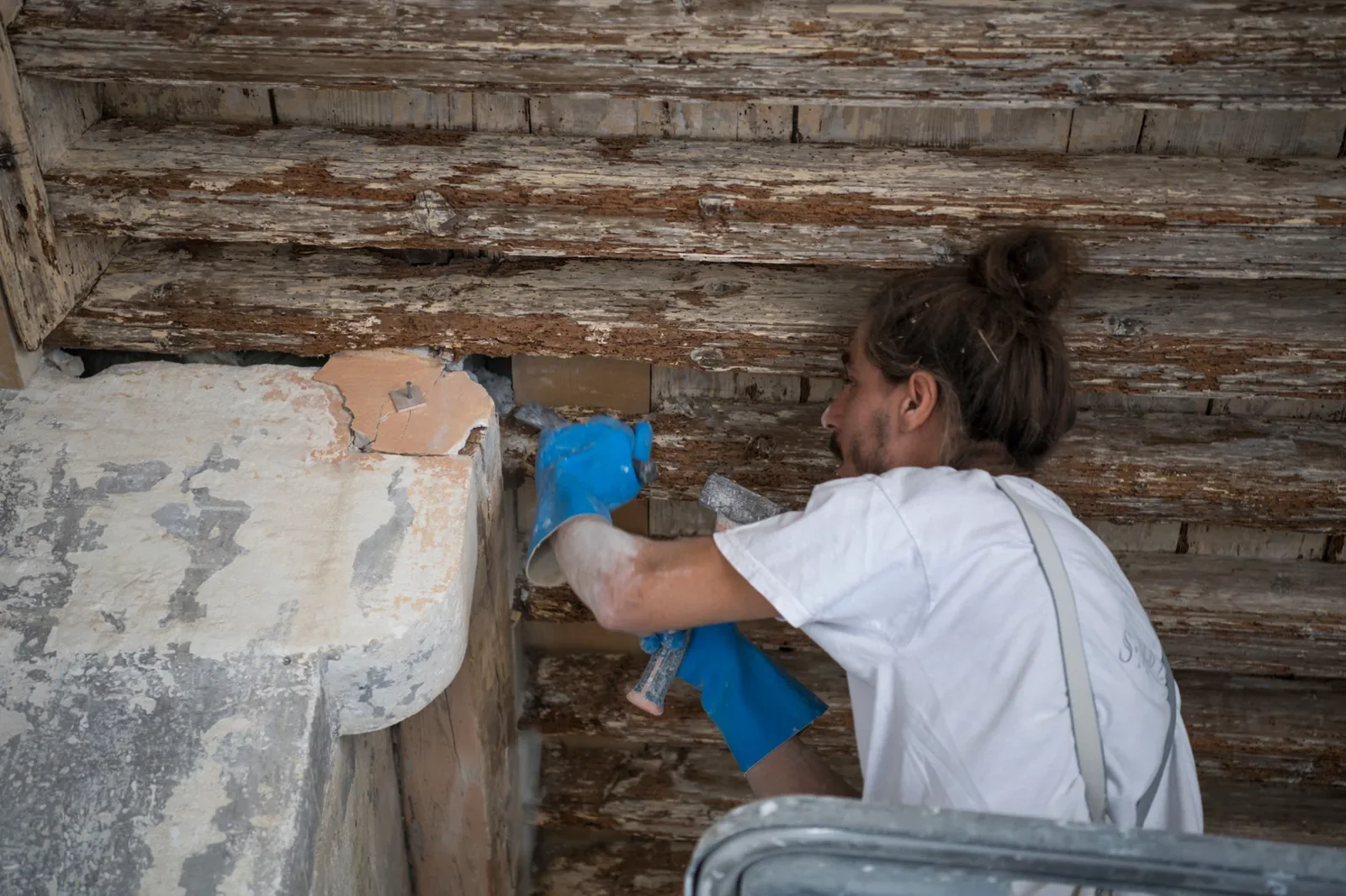 Artisan intervenant à l’intérieur d’un bâtiment patrimonial en cours de restauration