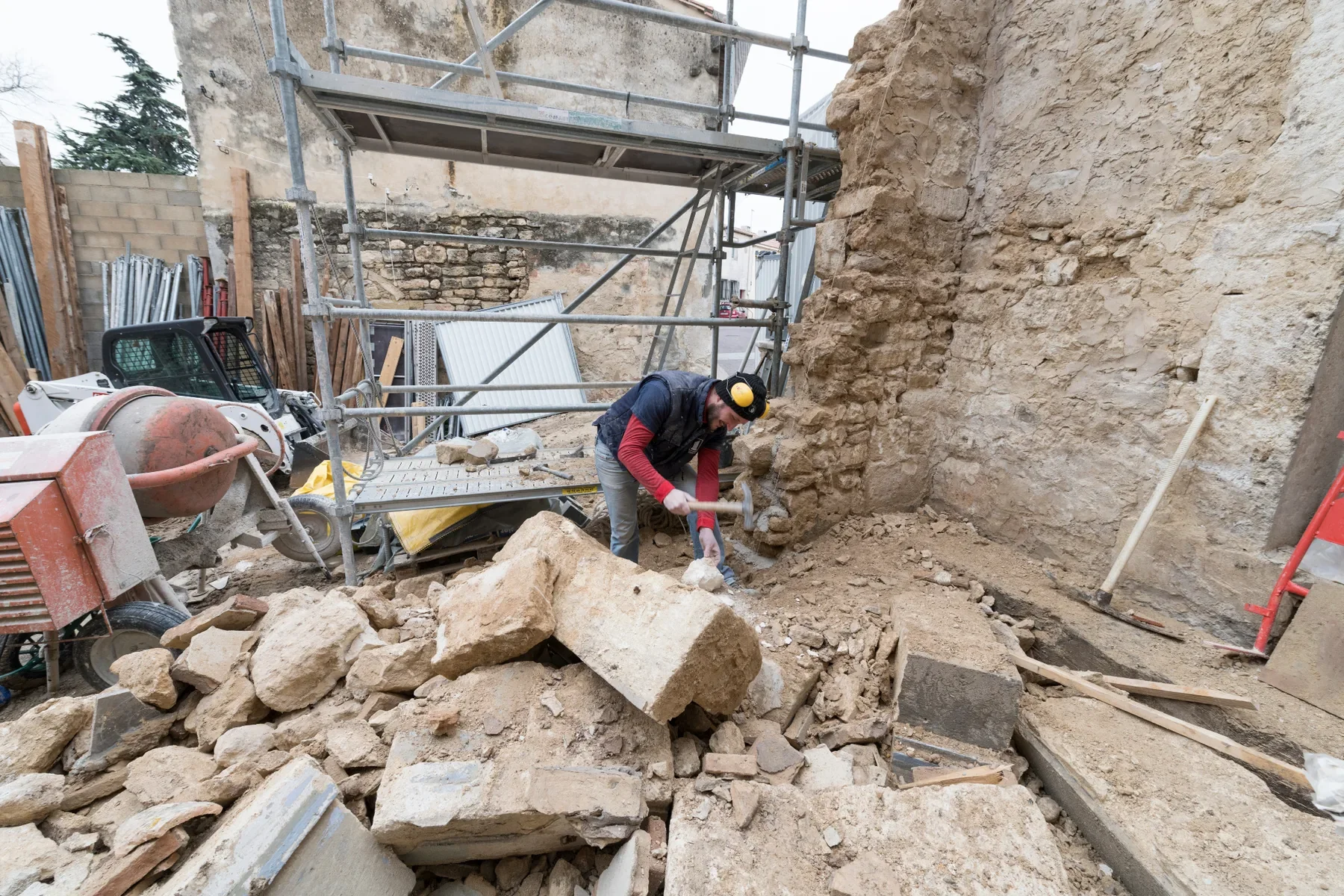 Artisan intervenant sur une maçonnerie ancienne lors d’un chantier de restauration patrimoniale