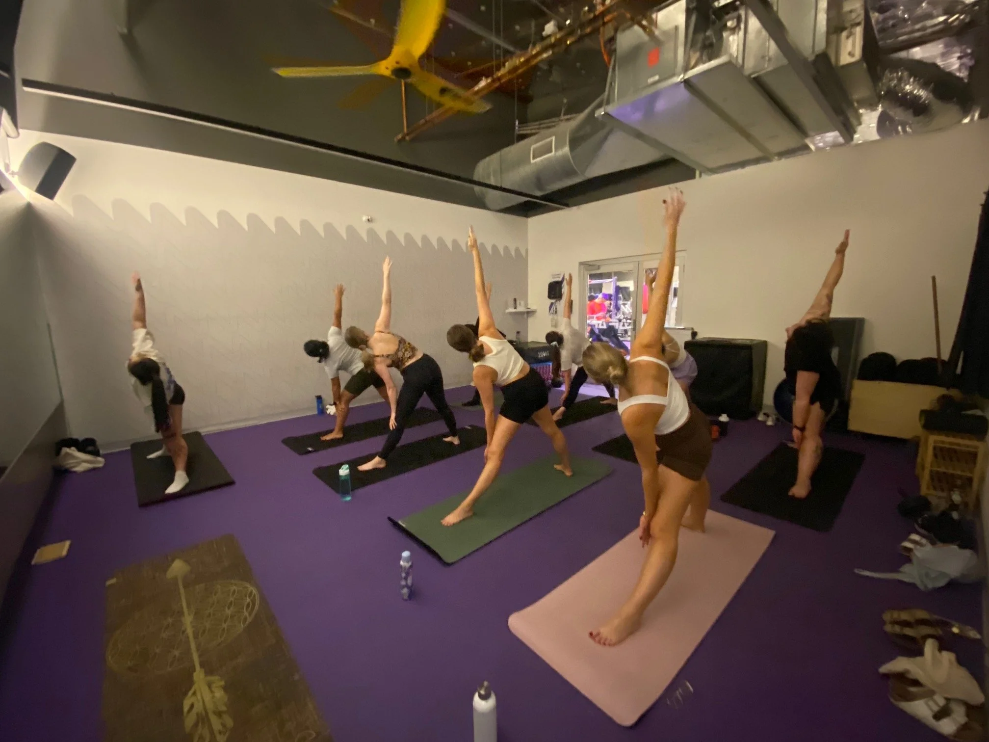 Grace teaching a group of people in a yoga class at Anytime Fitness Milton