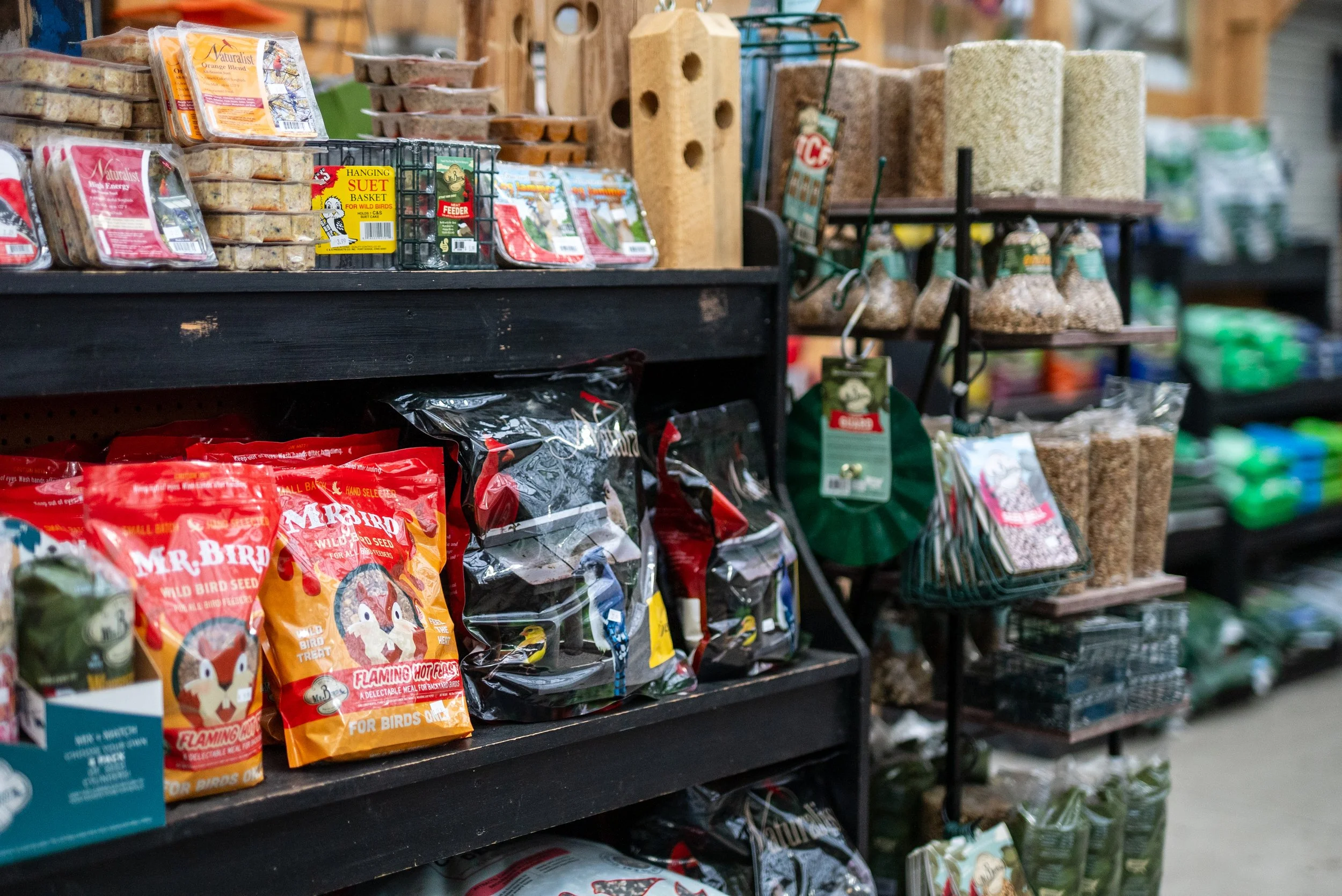 Bird seed bags and bird feeding supplies on store shelves.