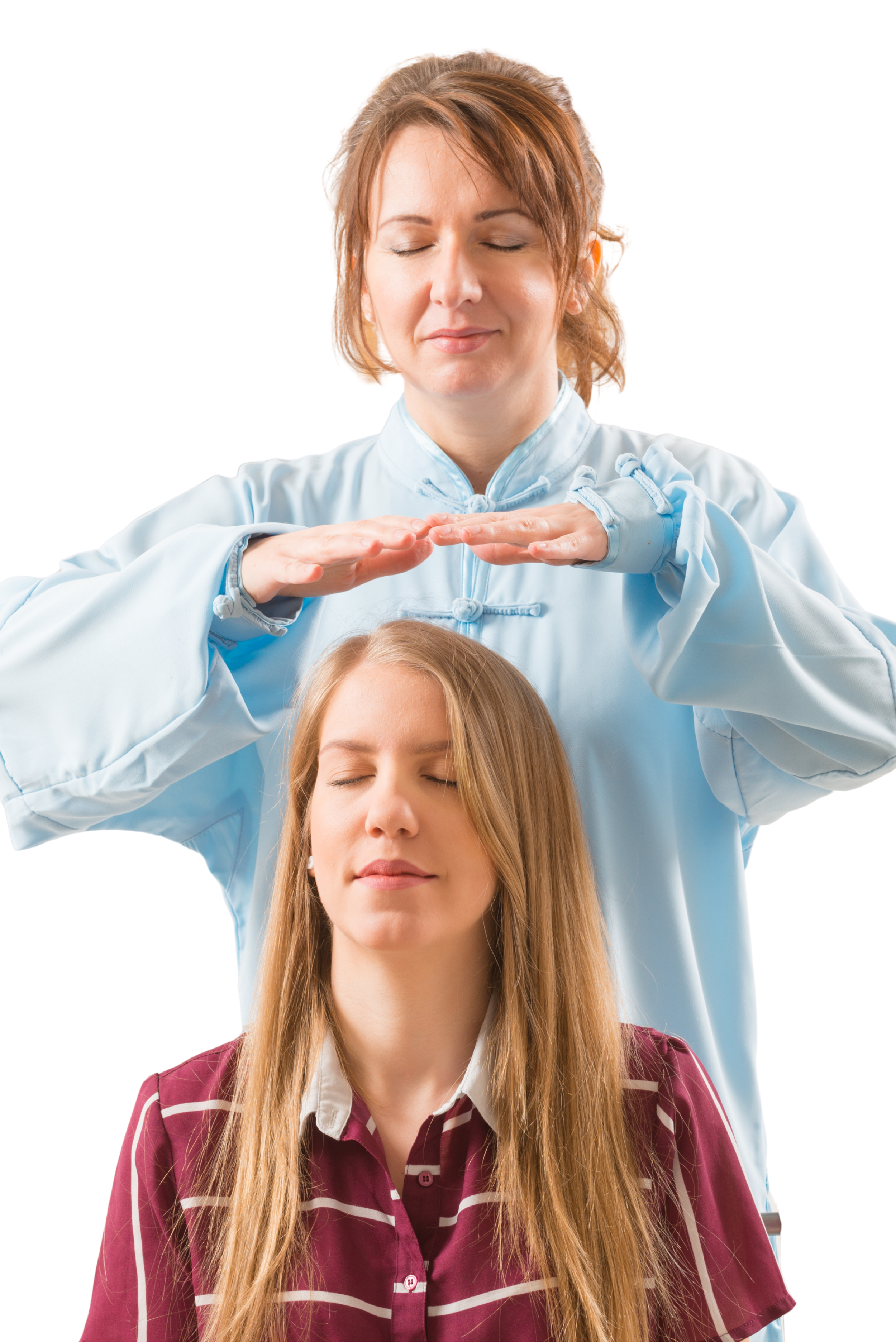 A woman in traditional Chinese clothing performs energy healing or meditation on a young woman with long blonde hair, who is sitting with her eyes closed and a calm expression.