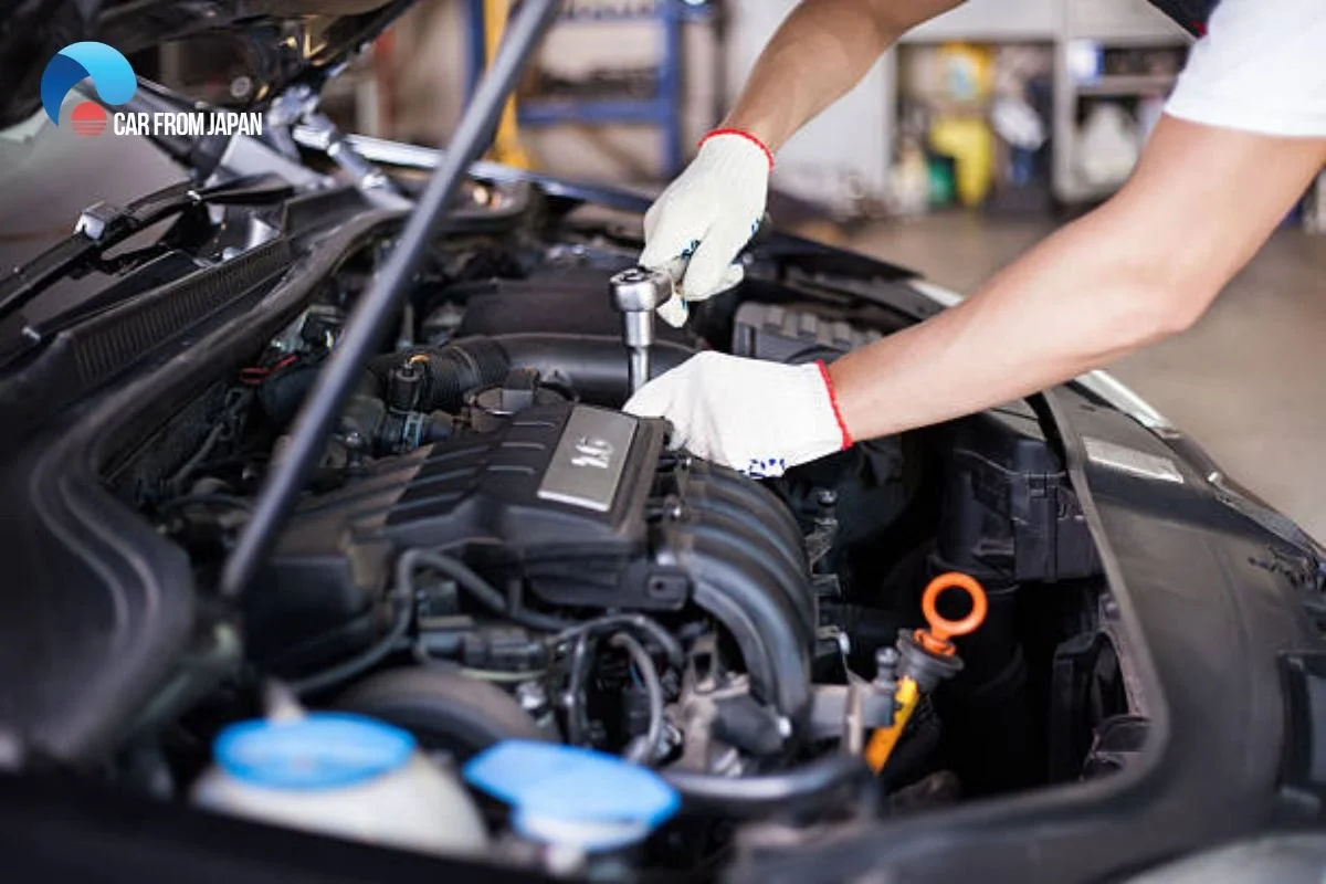 Mechanic working on car engine with socket wrench for auto repairs, AC tunings, and more