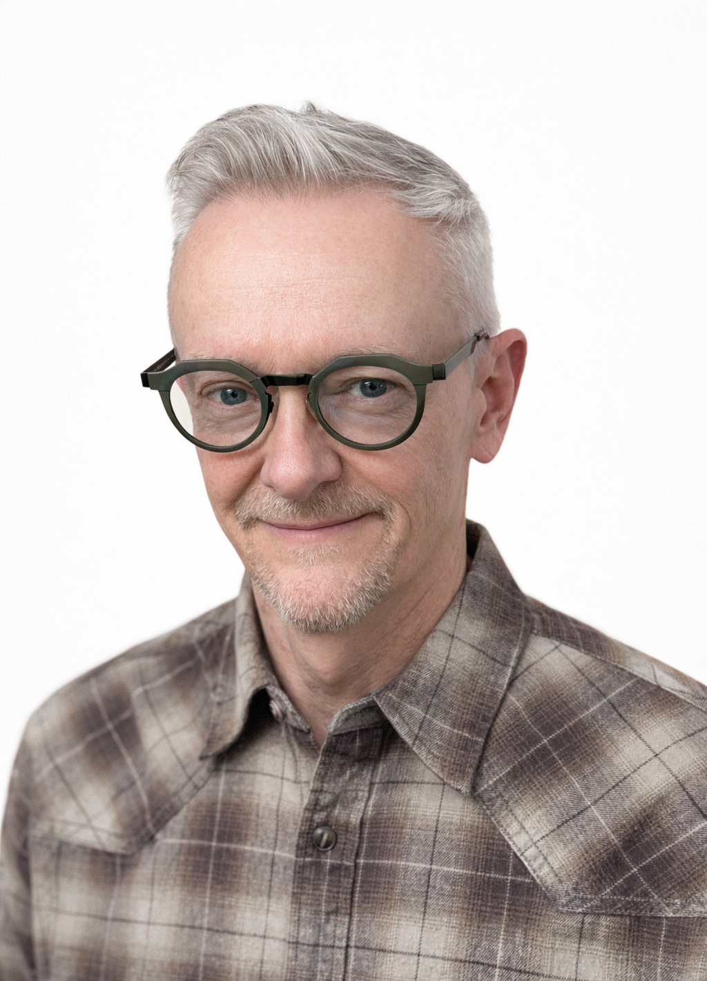 A middle-aged man with short gray hair, glasses, and a goatee, wearing a brown plaid shirt, smiling against a white background.