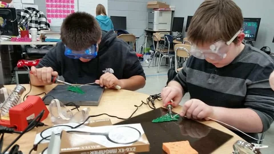 A pupil soldering a small circuit. 