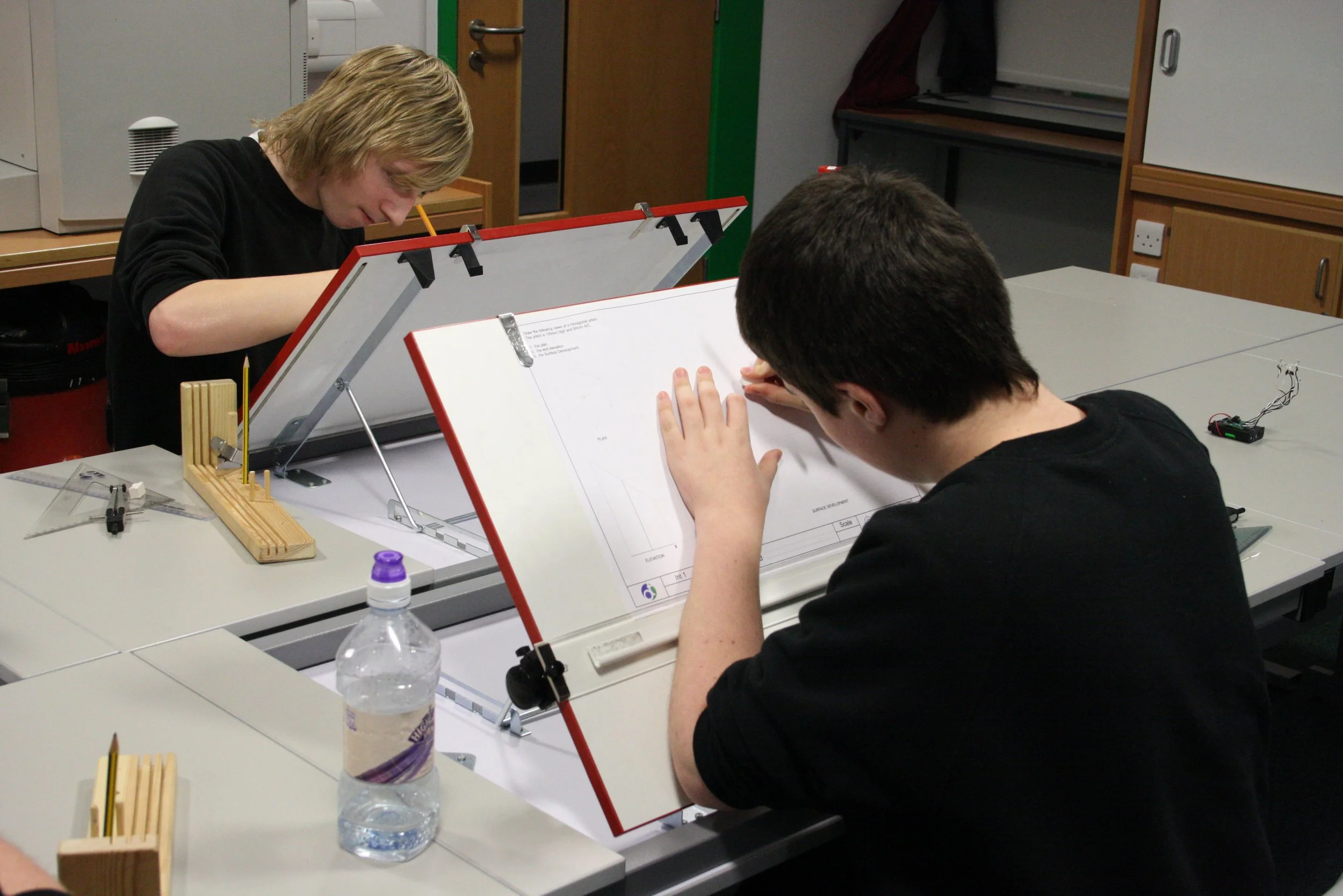 Two pupils using drawing board to create technical drawings