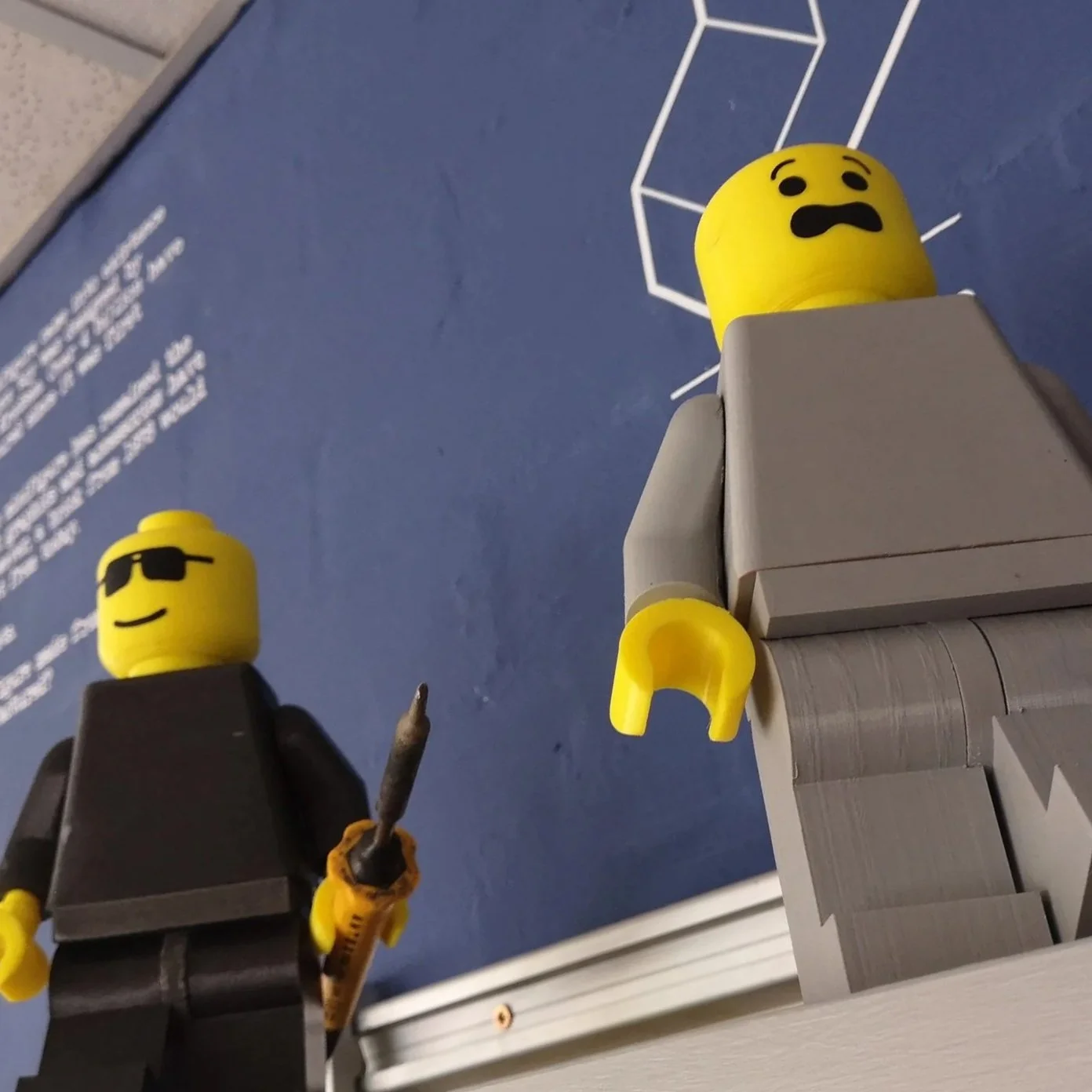 3D printed Lego mini-fig, about 5x larger than standard. The body is in grey plastic. The facial expression is worried or anxious.