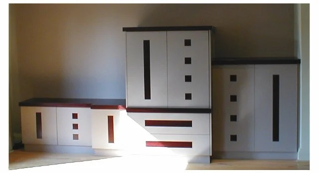 A set of three white cabinets with modern black and red accents, placed on the floor against a plain wall.