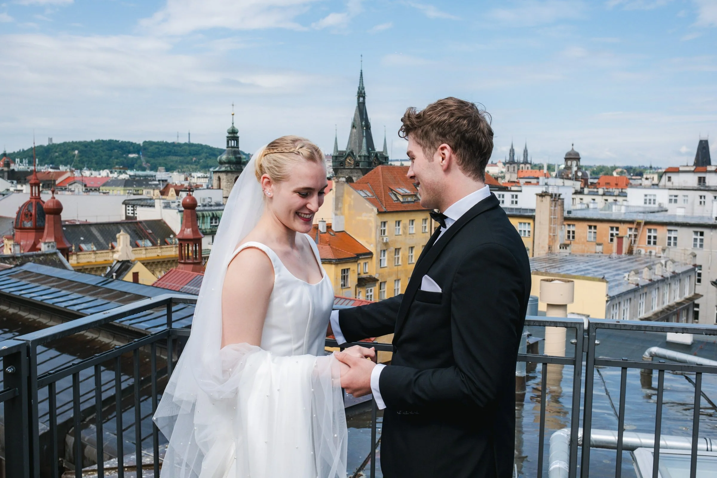 Intimate Prague elopement wedding portrait of an American couple on a rooftop overlooking Old Town, captured by a Prague wedding photographer.