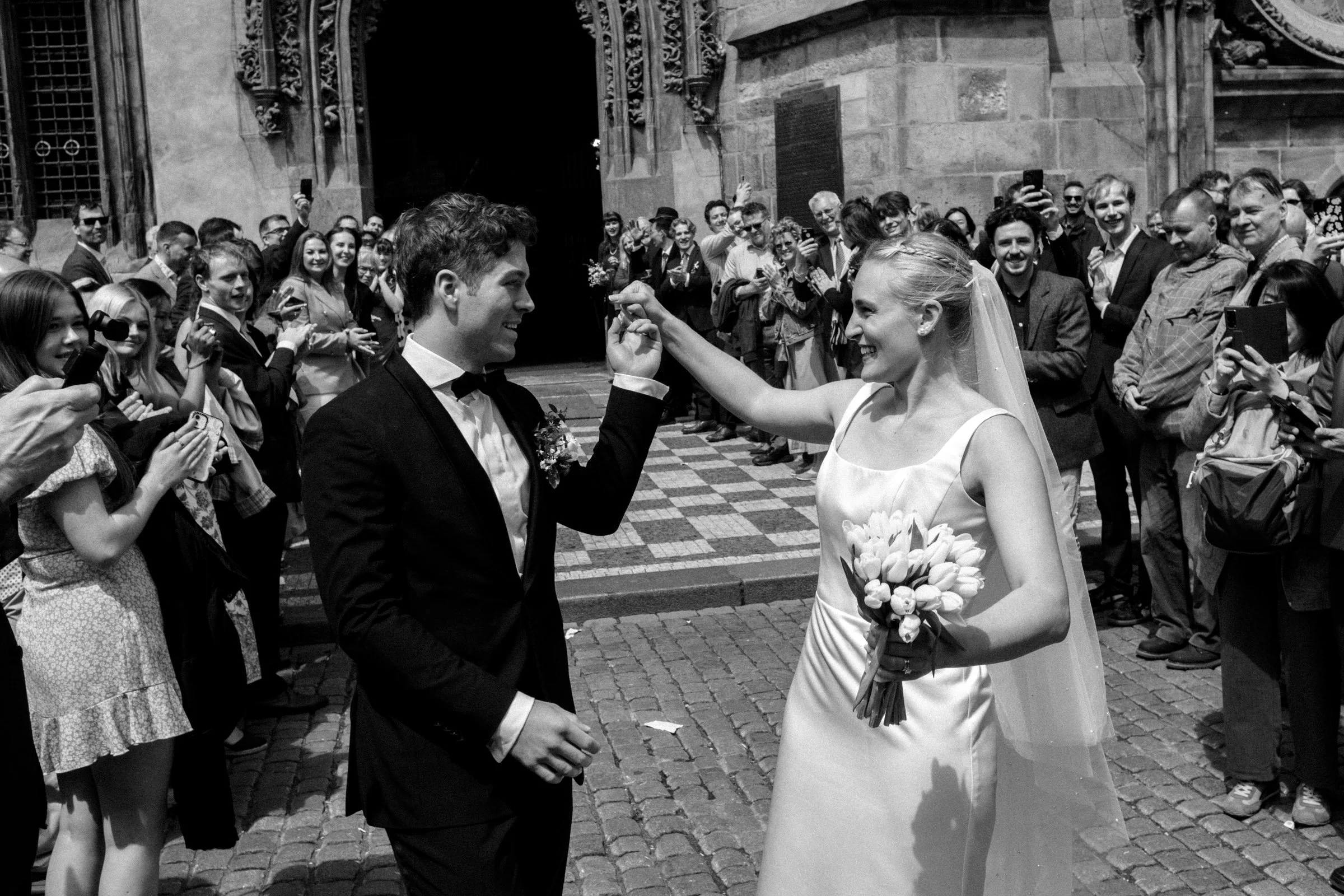 Newly married couple leaving Old Town Hall in Prague after an intimate elopement wedding ceremony.