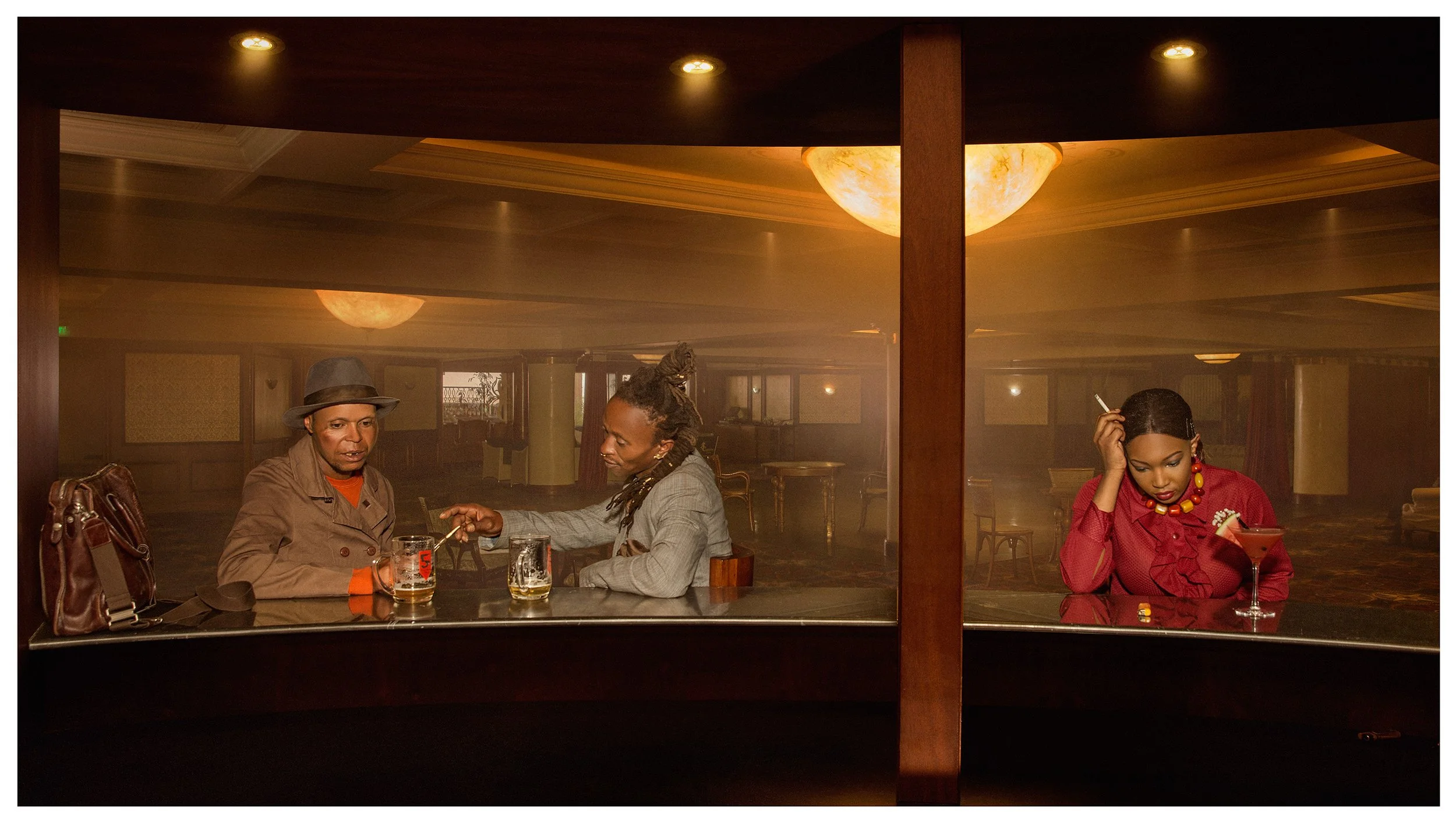 Three people sitting at a bar with drinks, two men and a woman. The scene appears to be in a dimly lit, retro-style bar or lounge.
