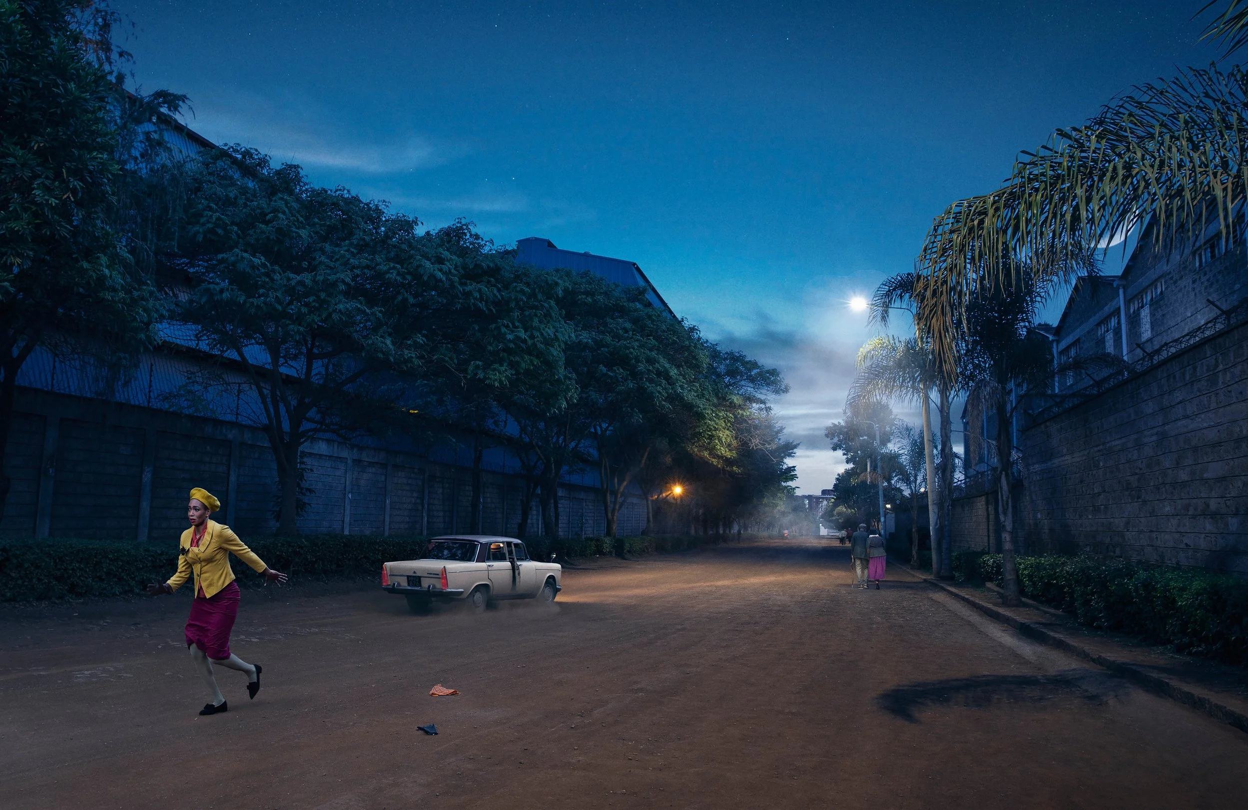 Nighttime street scene with a woman in a yellow jacket crossing the street, vintage white car parked nearby, trees on both sides, and a partly cloudy sky illuminated by the moon.