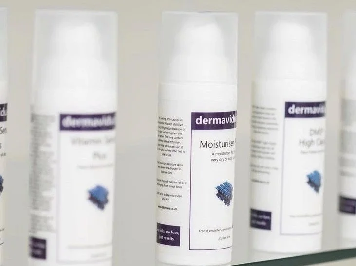 Skincare product bottles labeled 'dermavid' on a shelf.