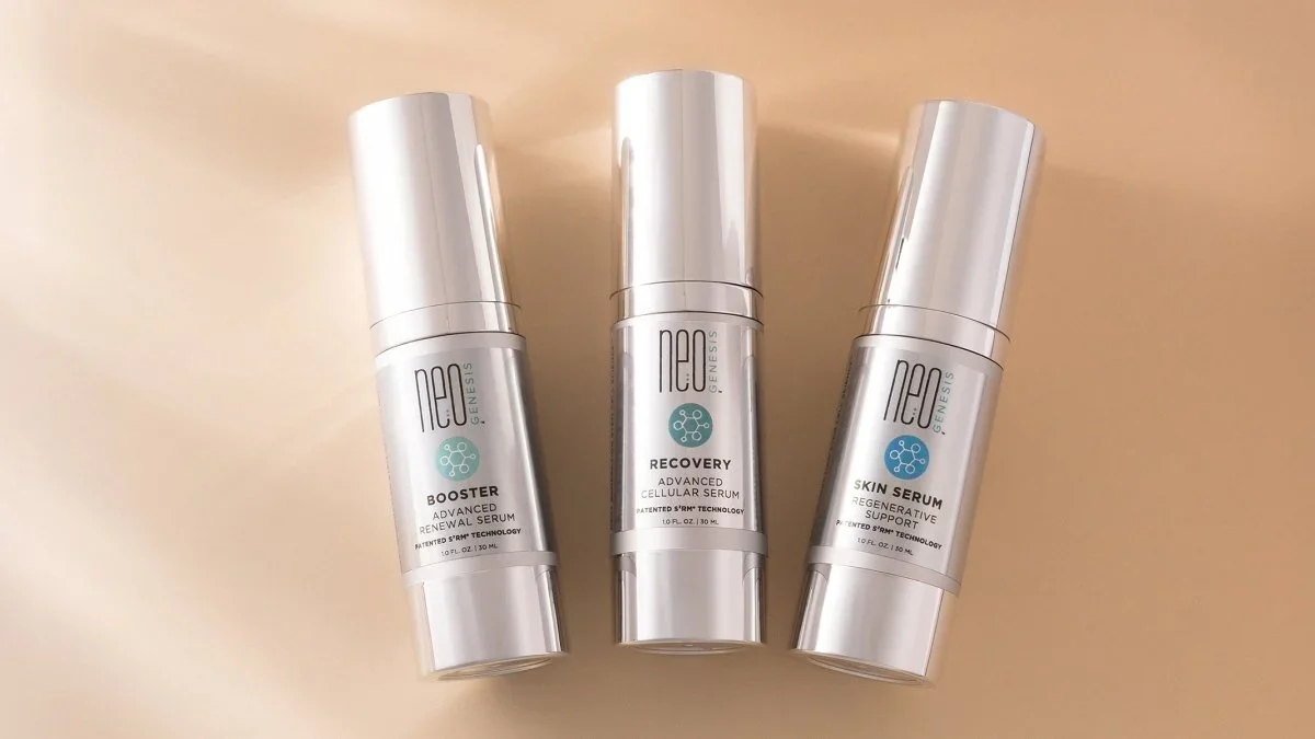 Three bottles of skincare serum, labeled Boost, Recovery, and Skin Serum, standing upright on a beige surface.