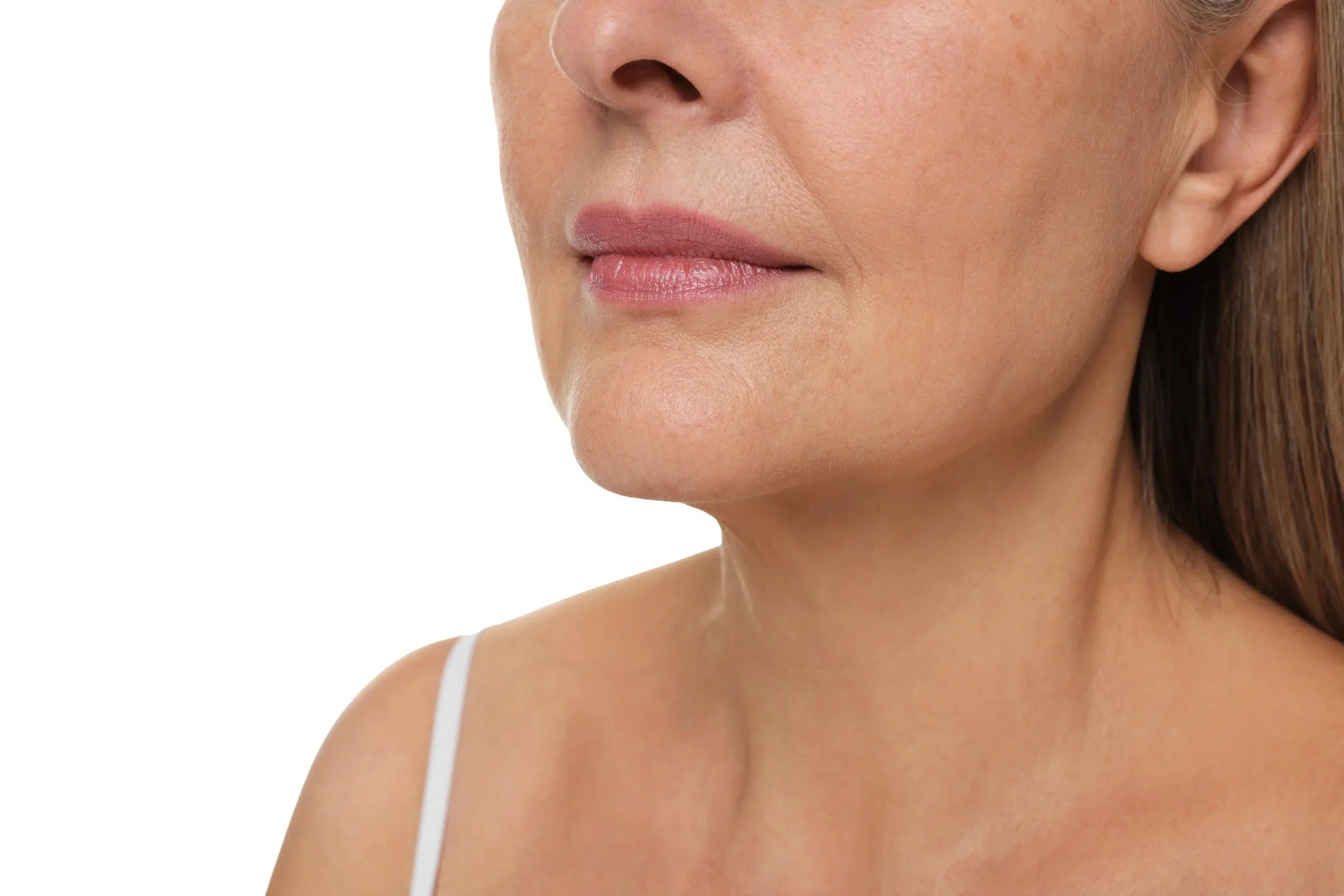 A close-up of a woman's face from the nose to the shoulder, with fair skin, light makeup, and brown hair.