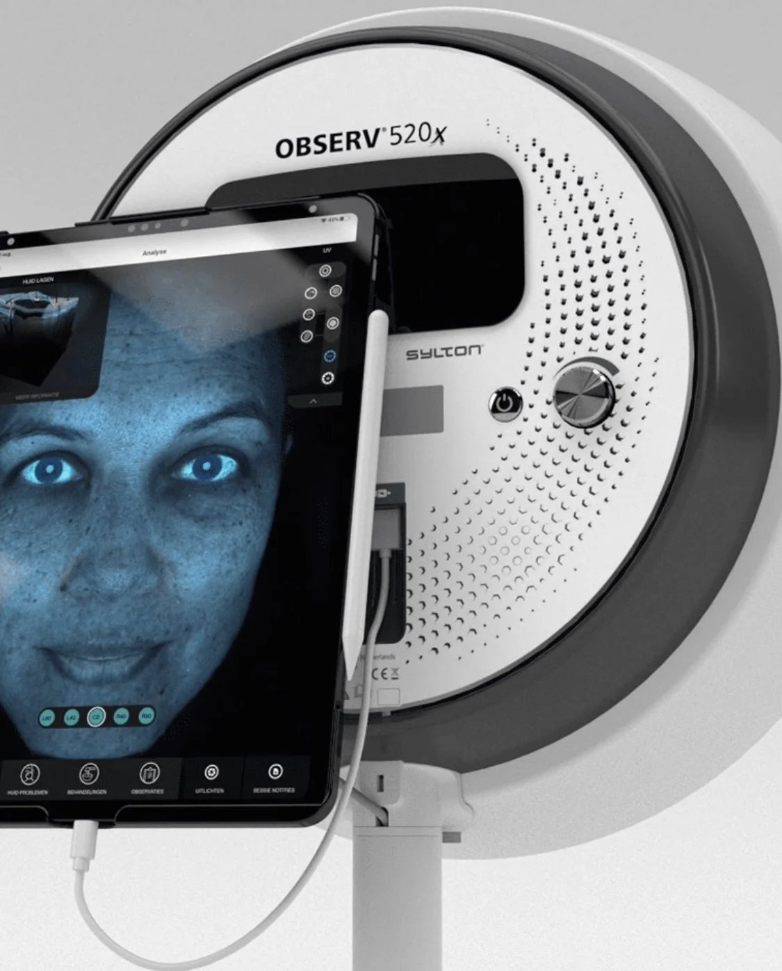A close-up of a medical or scientific imaging device with a smartphone showing a detailed image of a woman's face, including her bright blue eyes, freckles, and a slight smile.