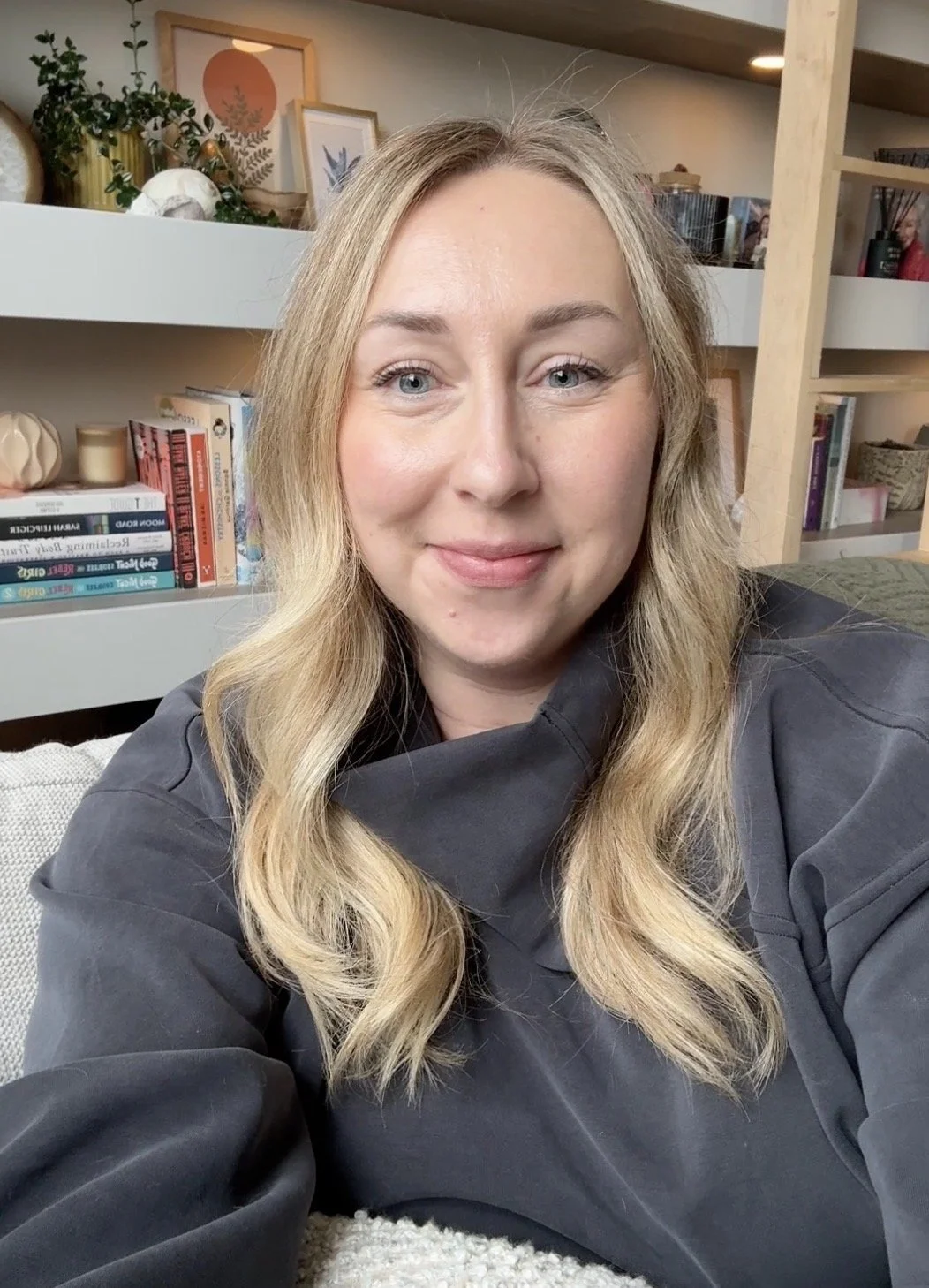 Erin Nelson, Alberta based Registered Dietitian of Sage and Spoon Nutrition smiling with a book shelf behind her