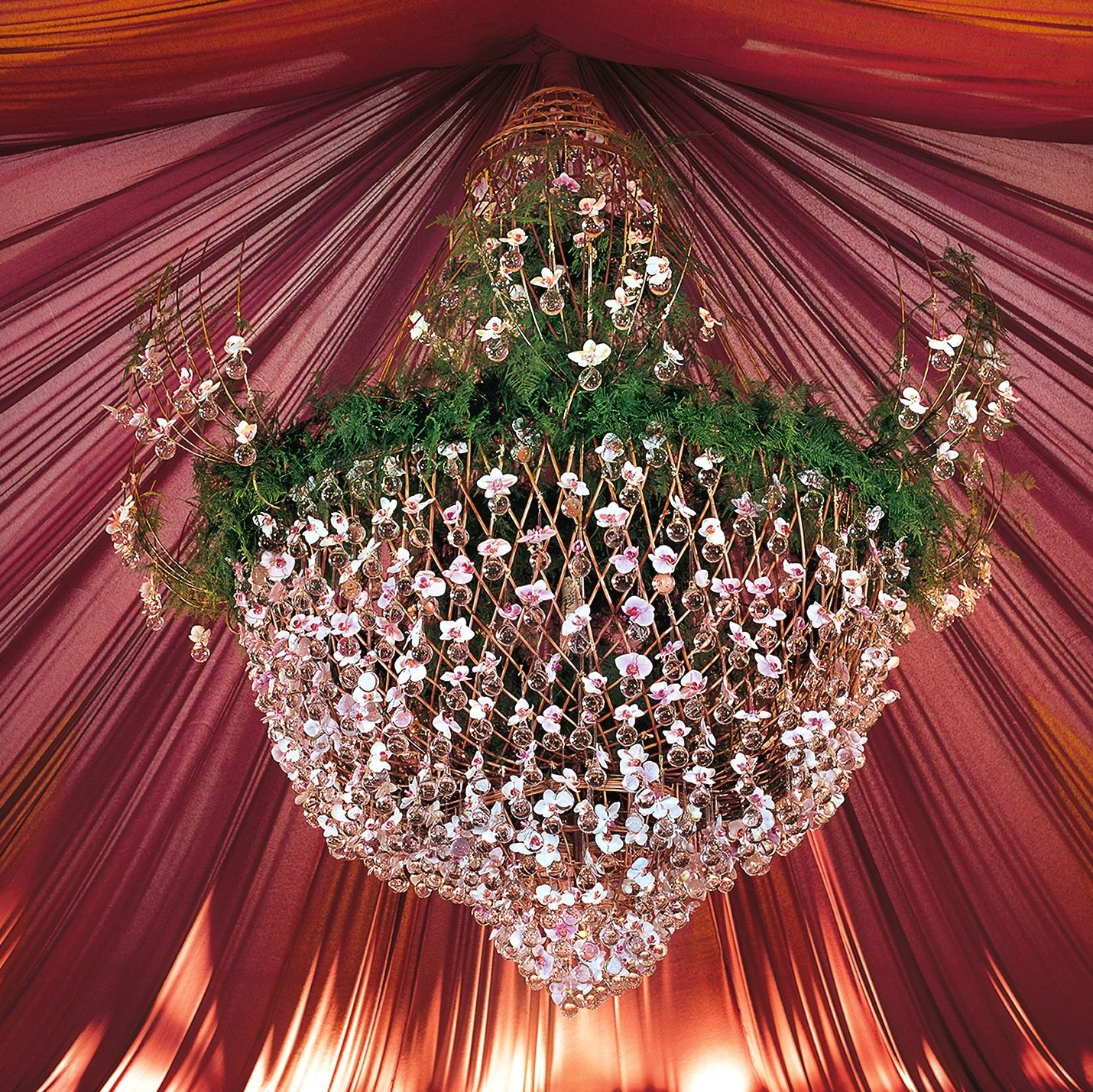 Luxury chandelier installation with cascading orchids and greenery at a high-end corporate gala.
